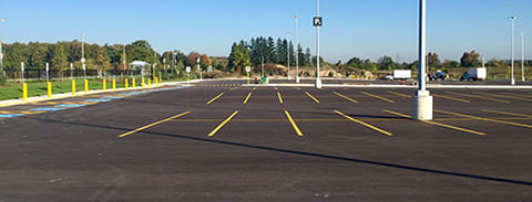 Photo of an empty parking lot of accessible and standard parking spots.