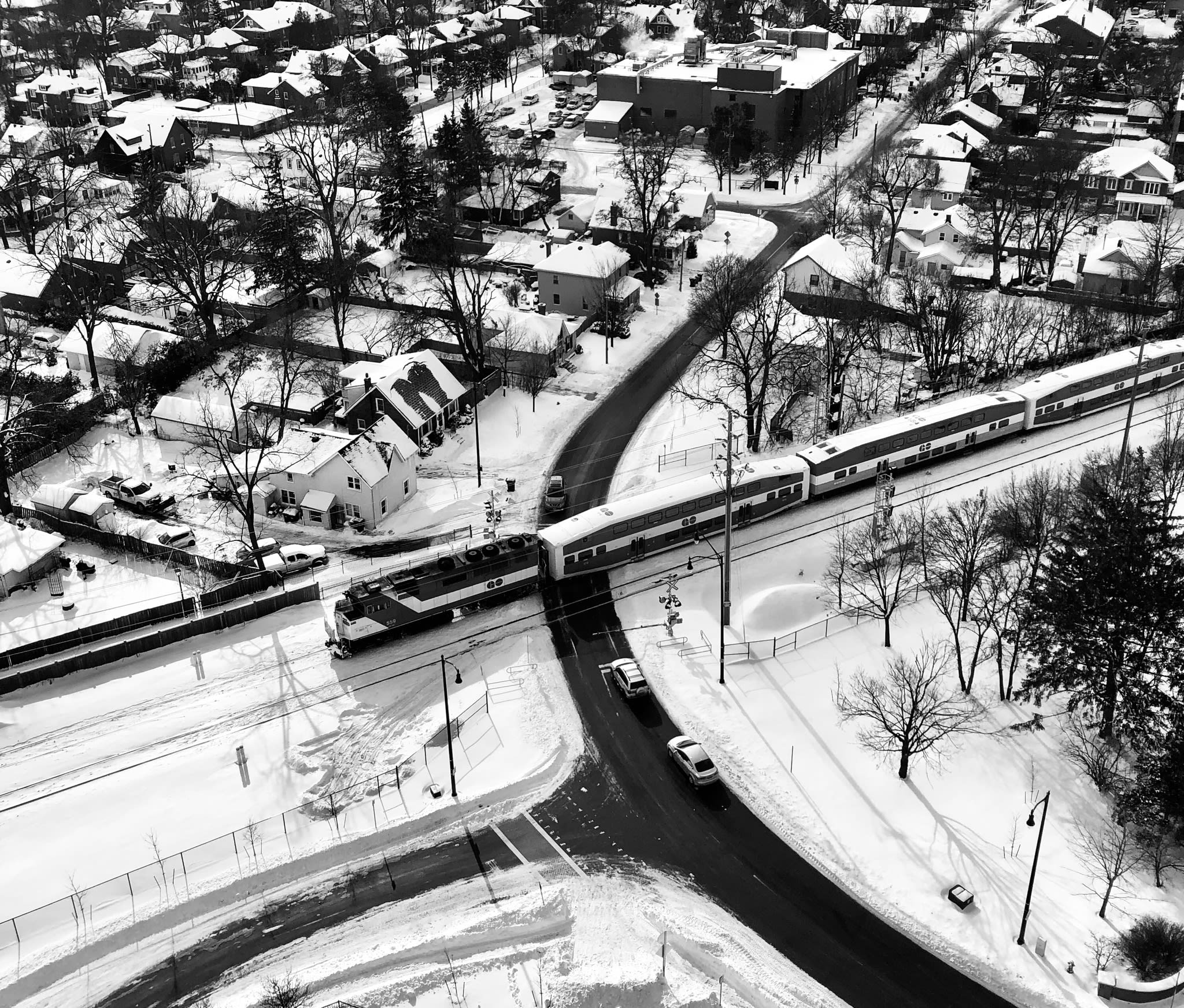 From high up in an apartment building, a GO train cuts across an intersection in Brampton. Snow c...