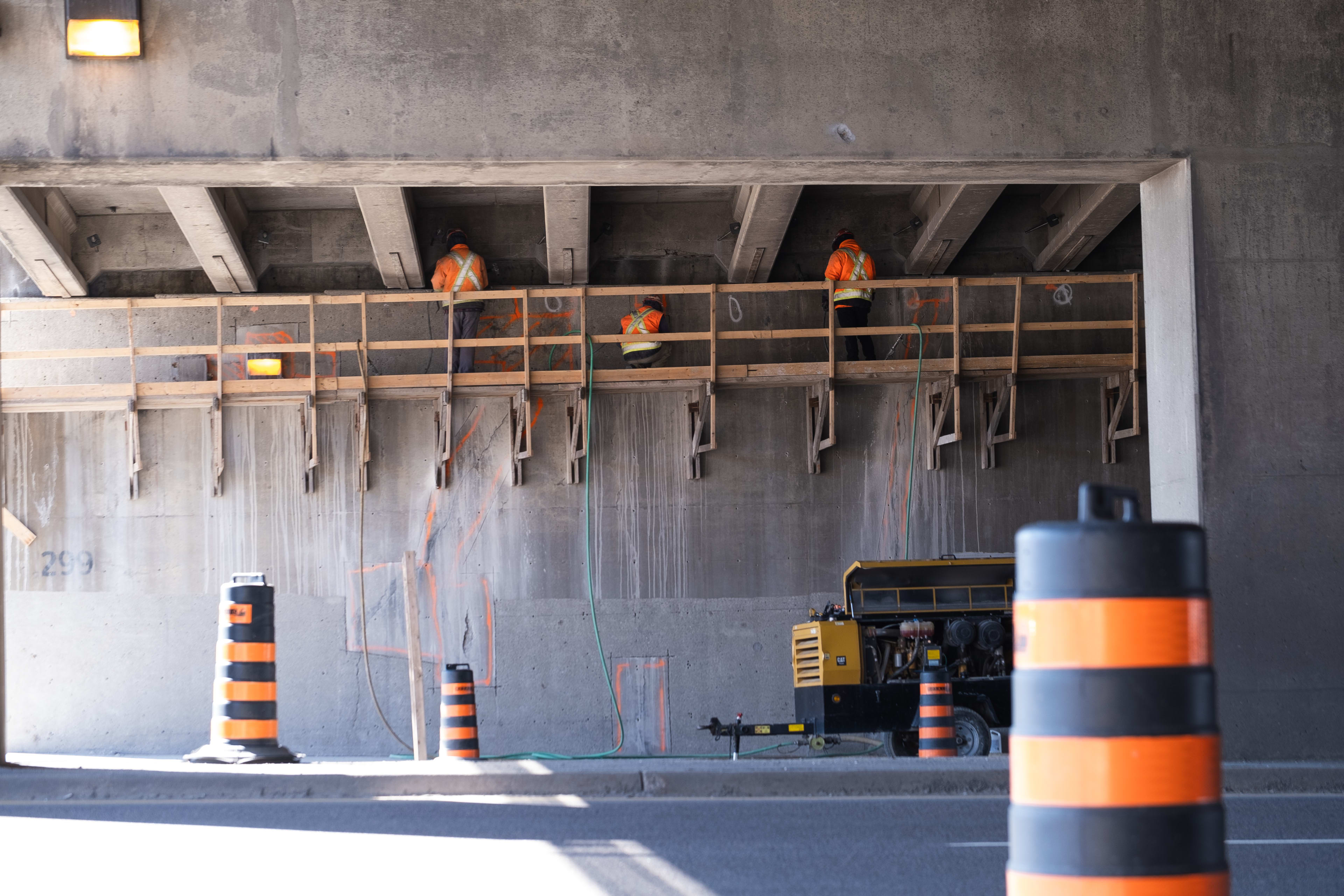 Crews work under a bridge.