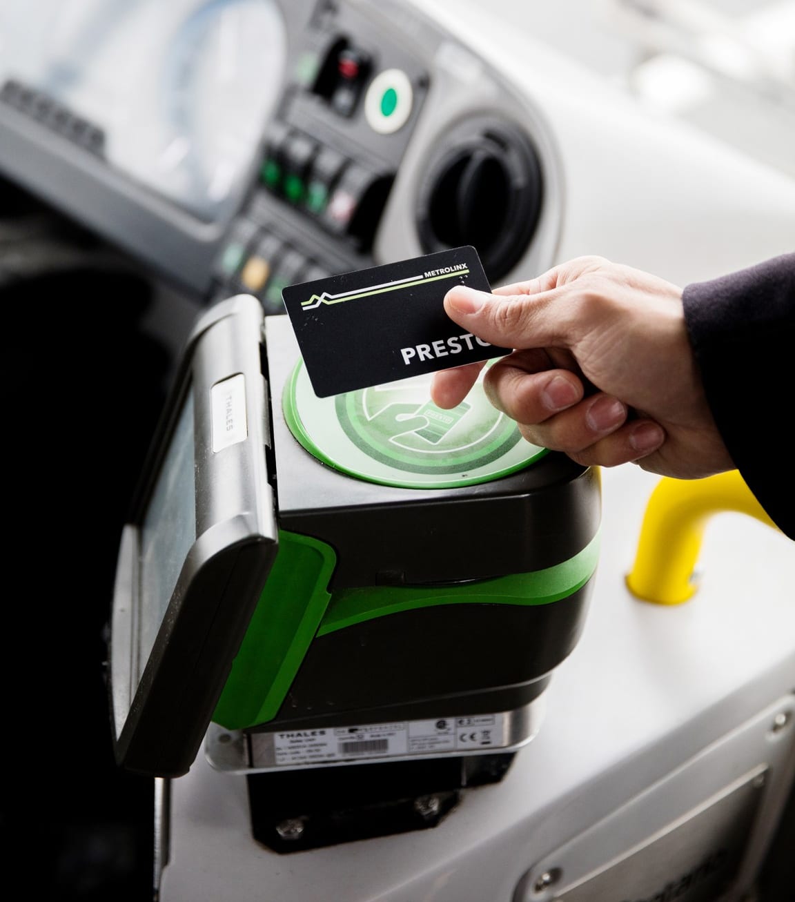 a person's hand tapping their PRESTO card on a PRESTO device.