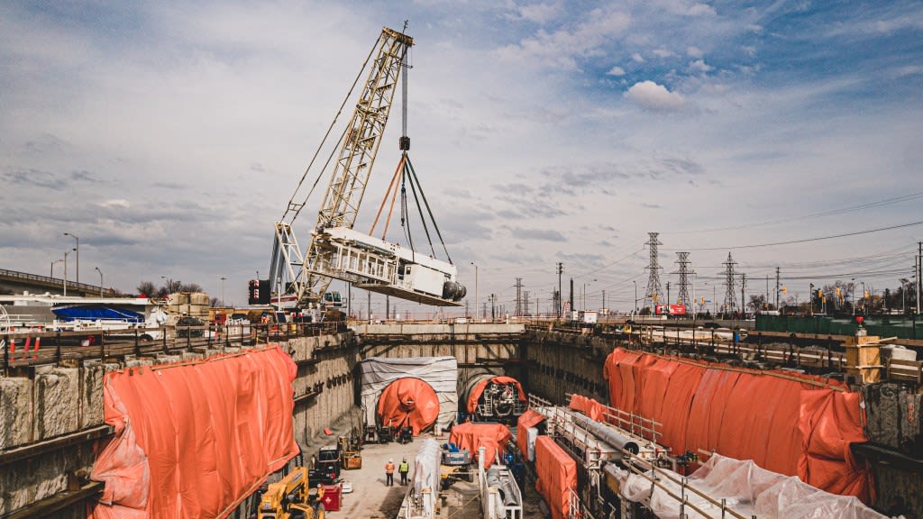 The bridge of one of the TBMs is lowered into the launch shaft site by crane in Feb. 2022.