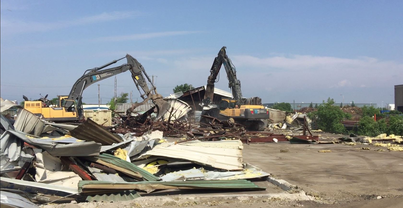 Tractors tear apart rubble and debris.