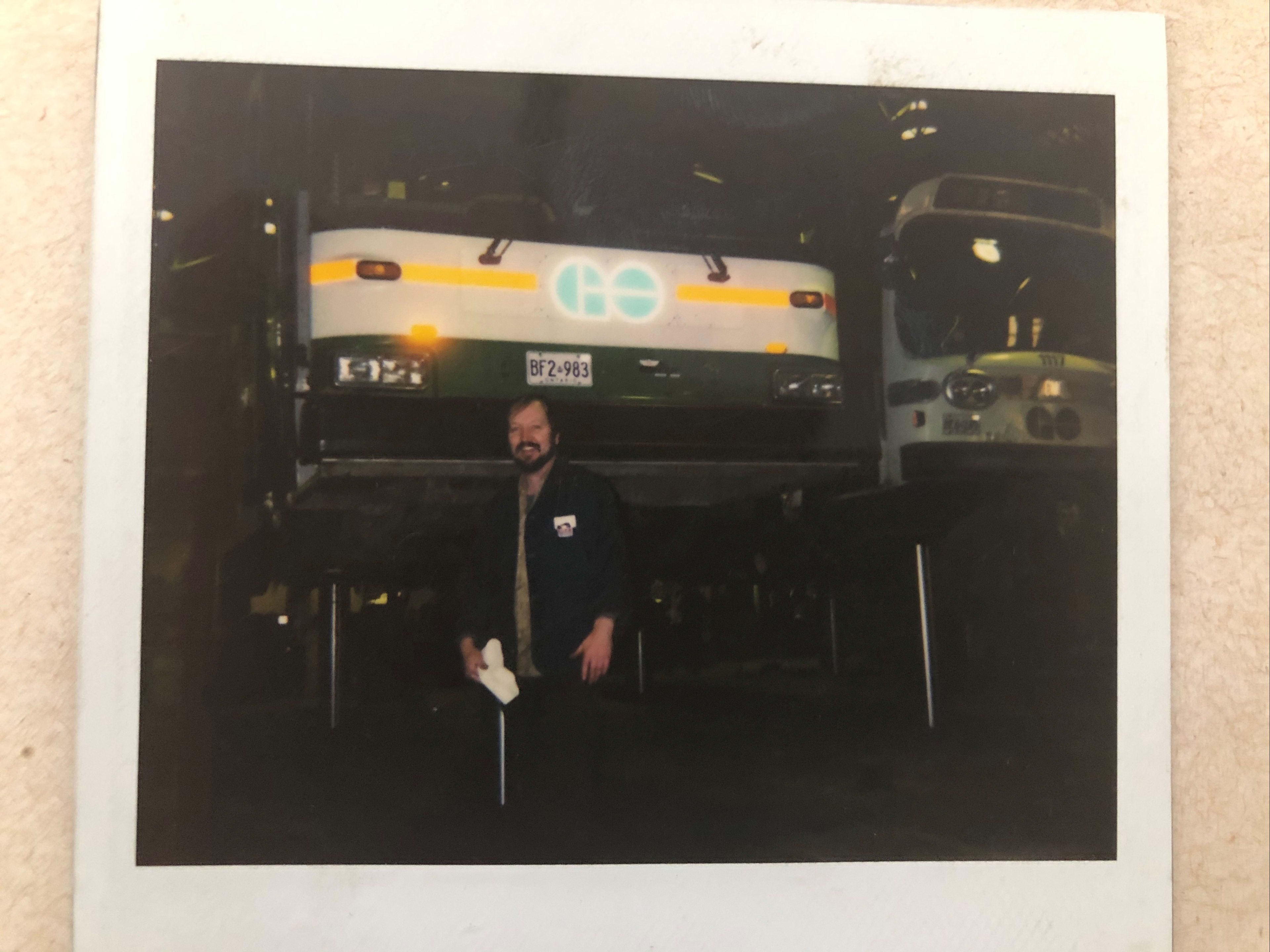 Chris stands in front of a bus.