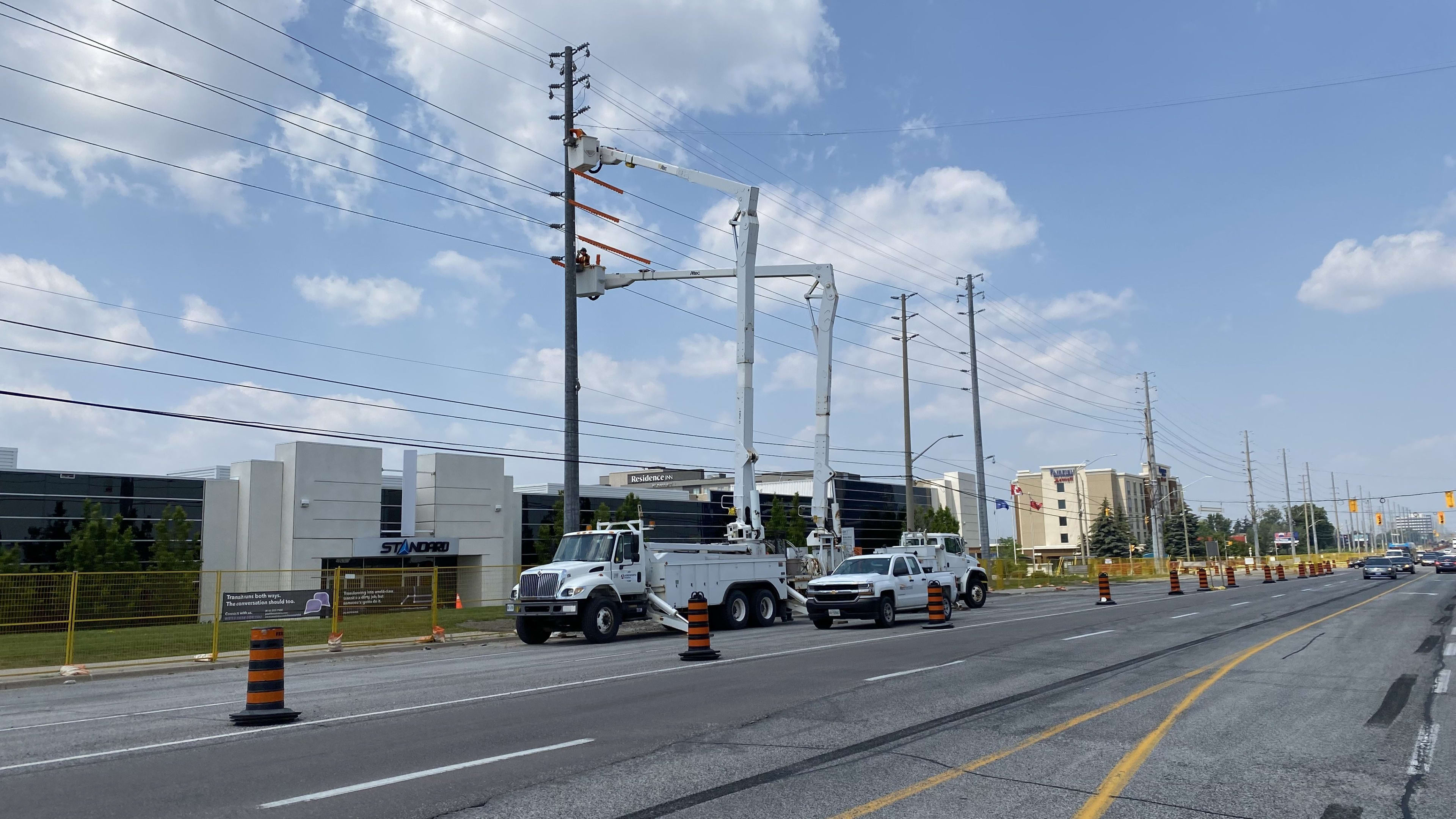 Bucket trucks installing new electrical poles near Hurontario Street and Courtneypark Boulevard