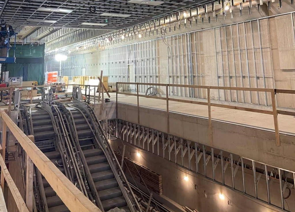 The station concourse under construction at Kennedy Crosstown LRT station with escalators in the ...