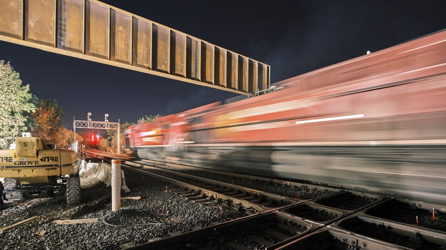 a freight train passes by the tracks in a blur