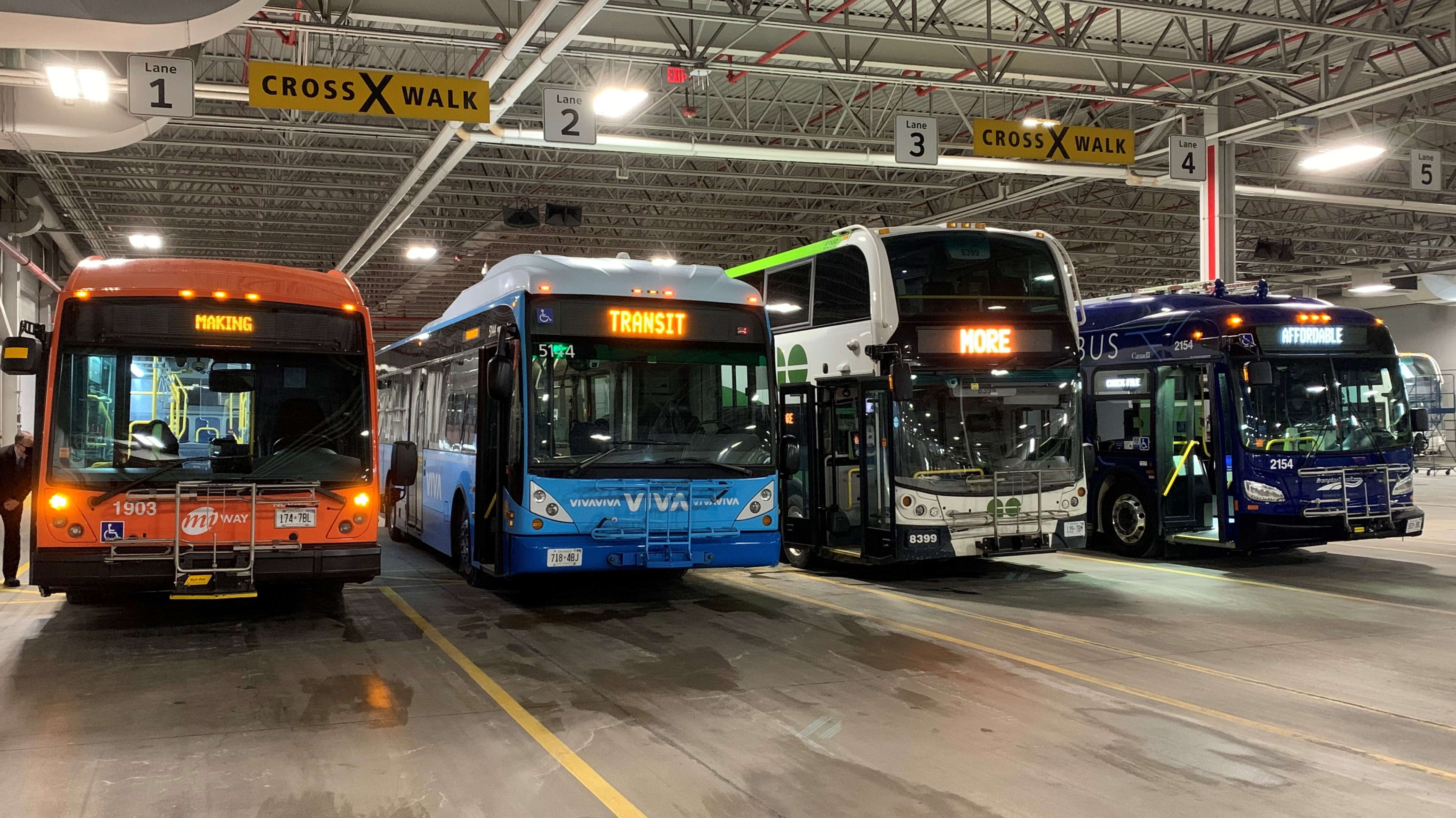 four transit buses parked next to each other