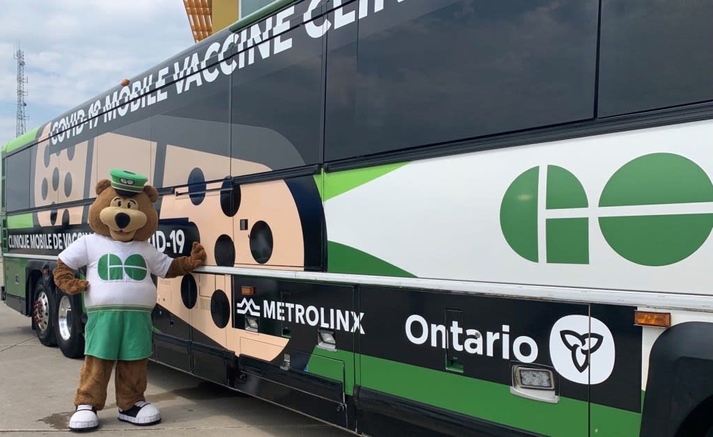 GO Bear is shown outside one of the VAXX buses.