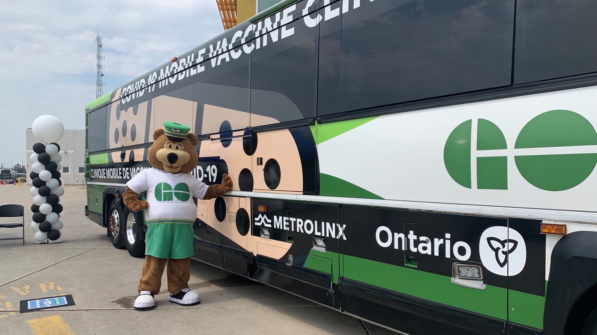 GO bear standing with special GO bus mobile vaccine clinic