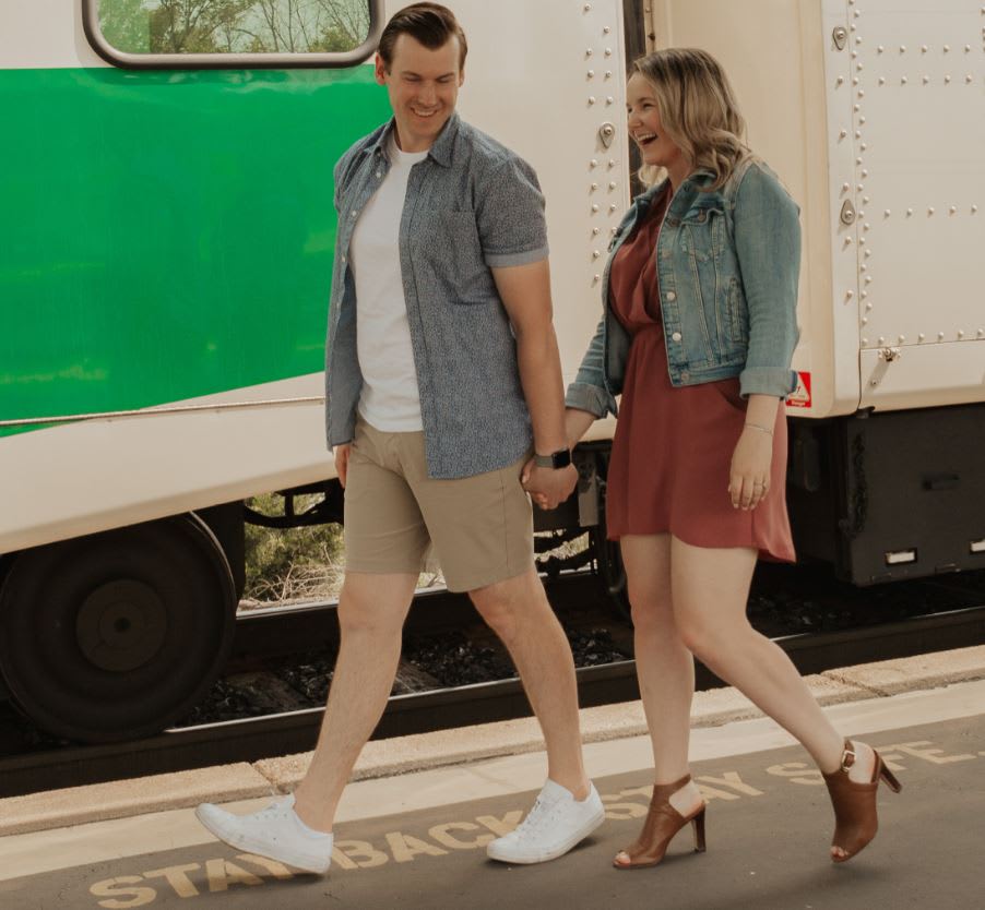 The couple walk beside a GO train