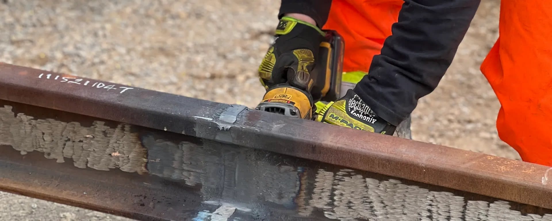 A worker grinds a welding seam with a special tool