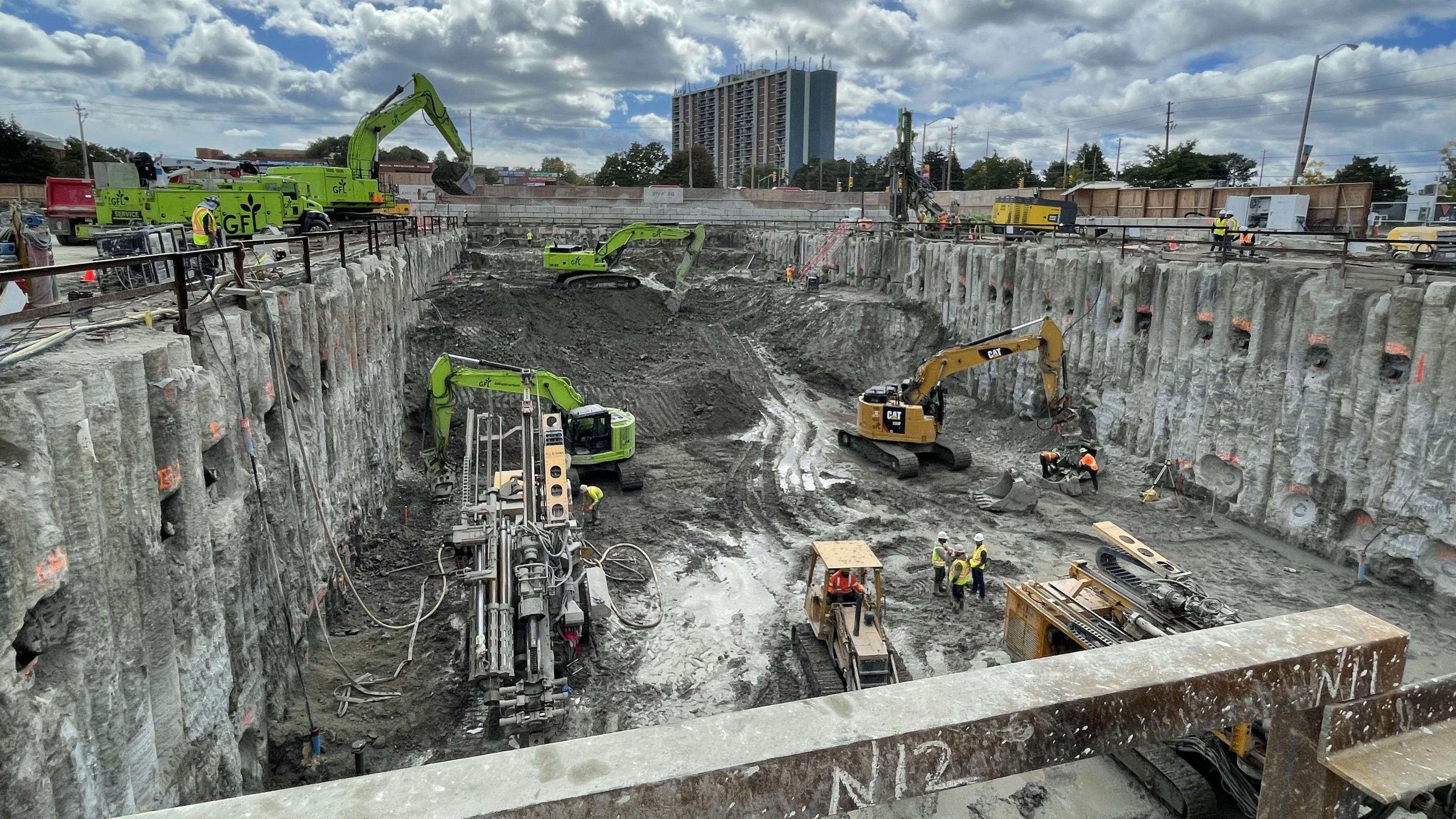 Excavators and other heavy machinery digging in a large excavation