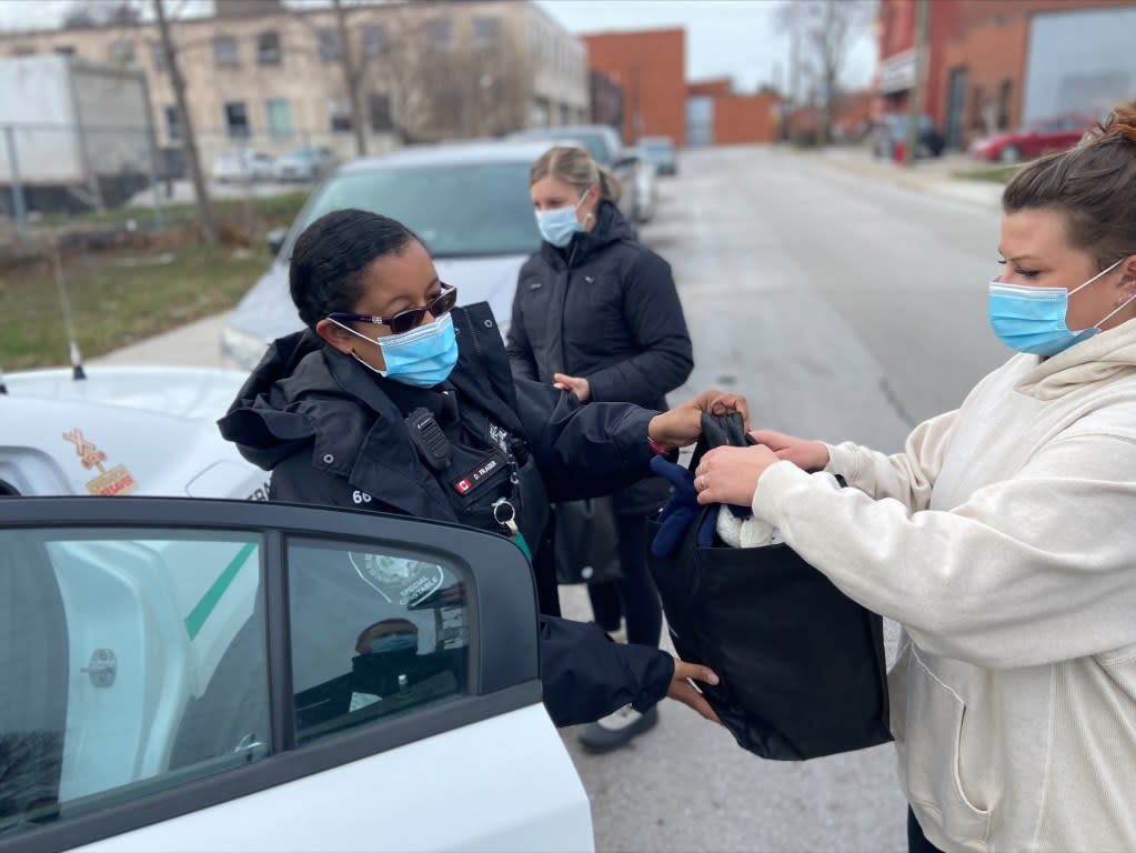 People are seen carrying the bags from a vehicle.