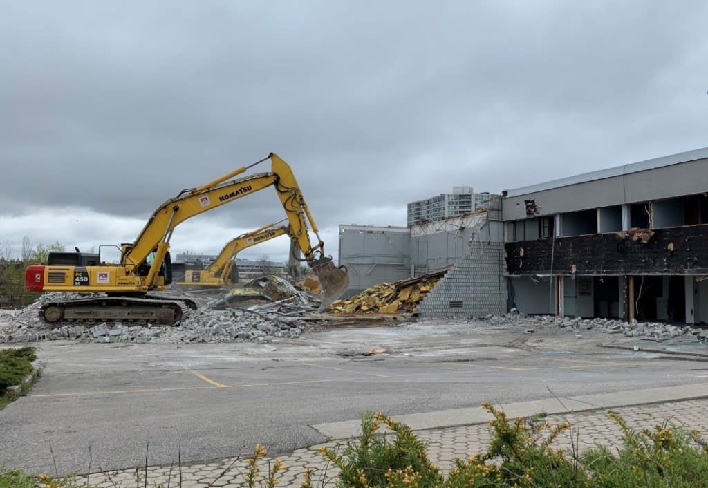 a large machine tearing away at a building.