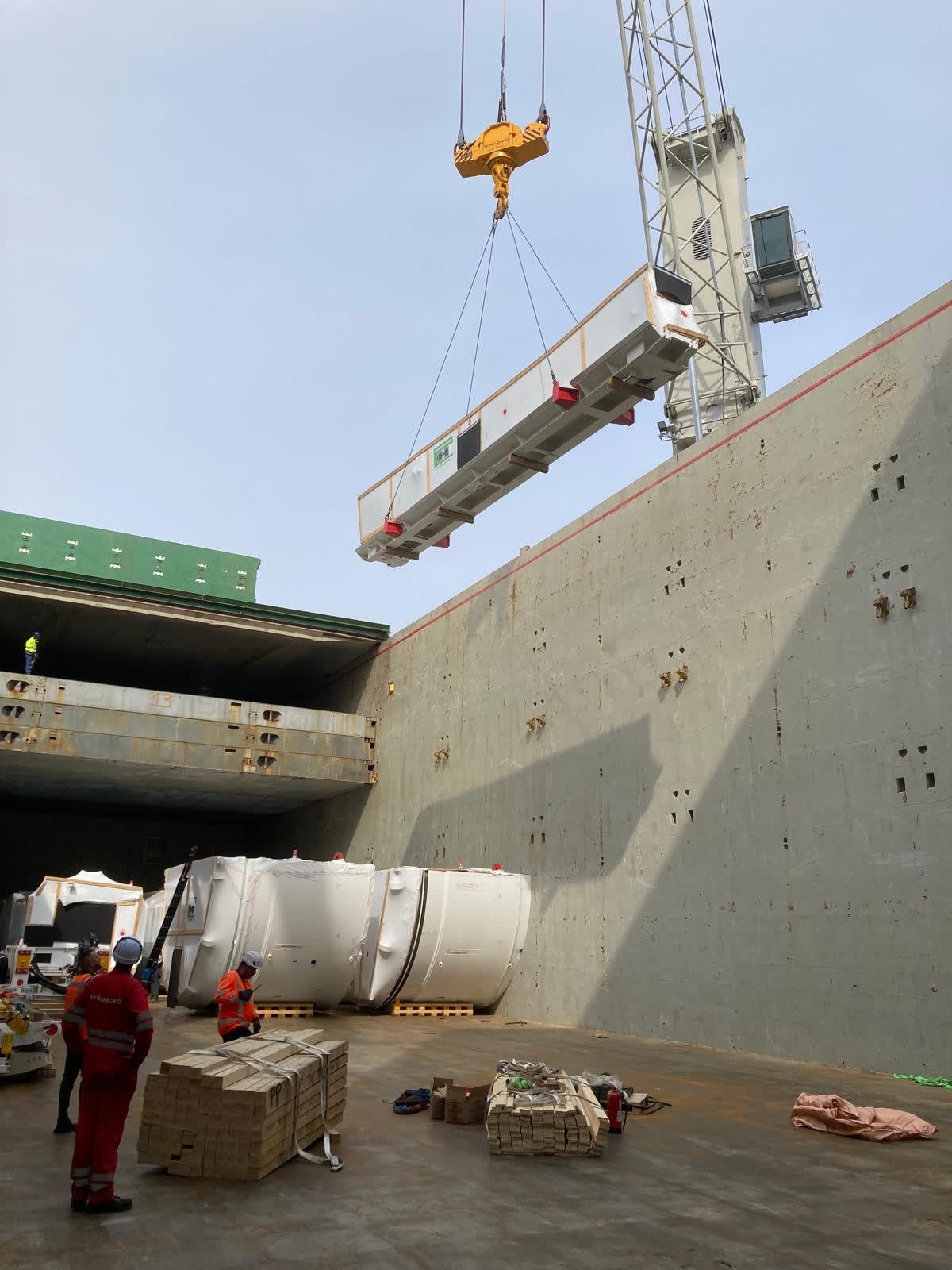 Photos showing pieces of the OL TBMs being loaded onto the boat for transfer