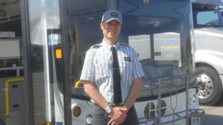 James C. Smith, a 20-year GO bus driver veteran stands with his bus