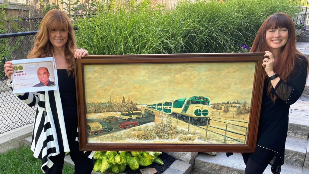Fred Bentley's daughters Julie and Lisa hold the one-of-a-kind painting done by a local artist in...