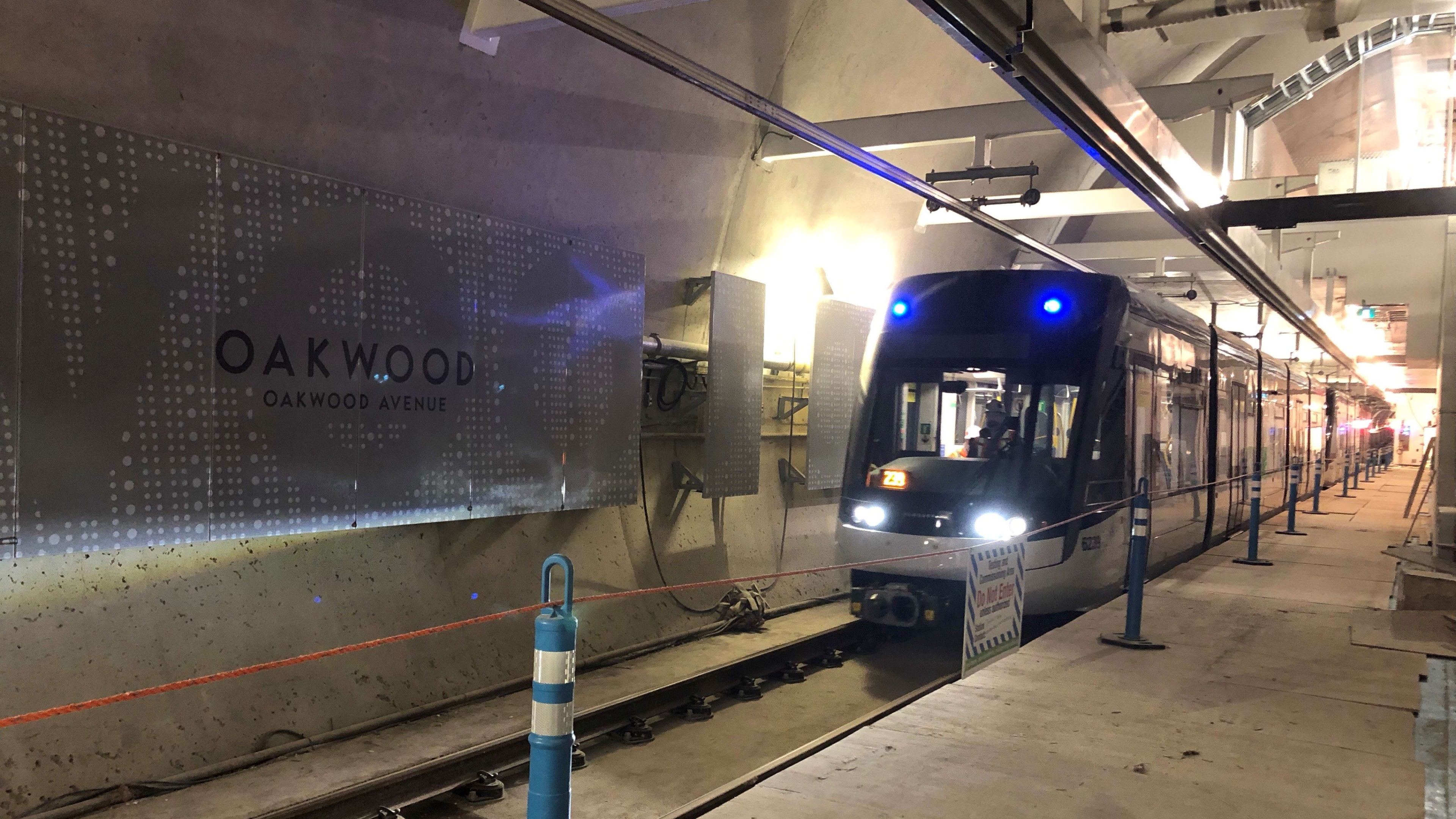 the train moving down the track, next to the Oakwood sign.