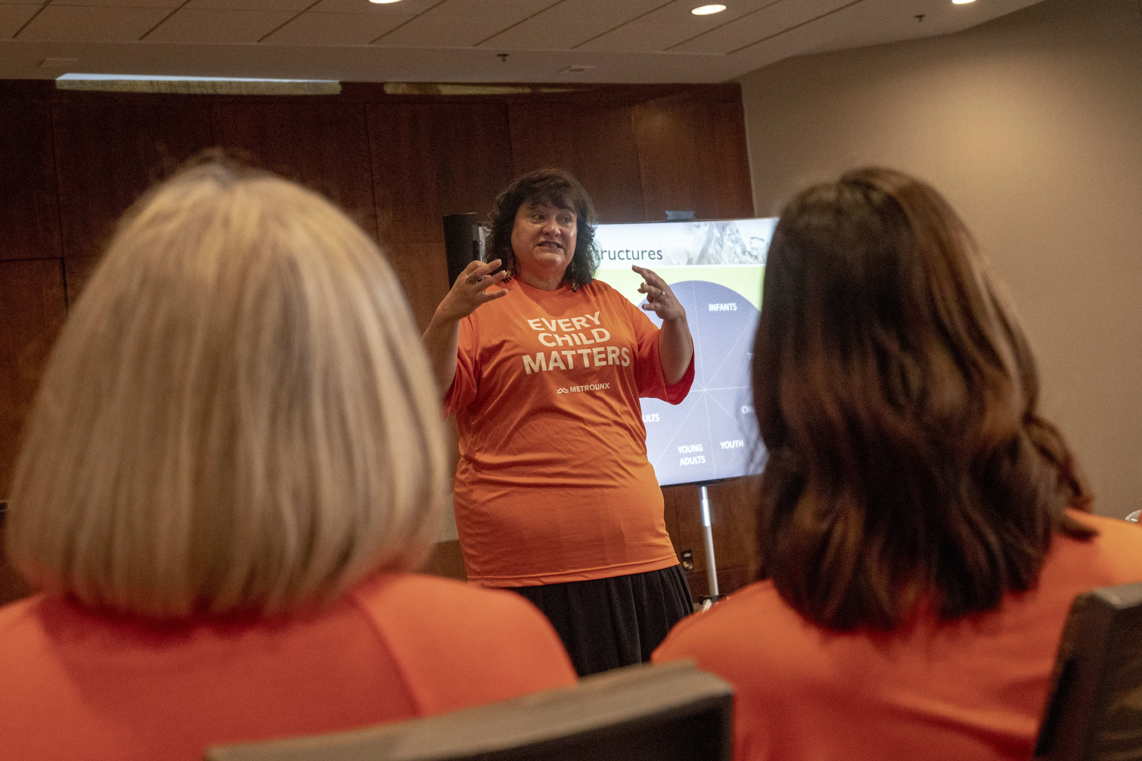 A speaker shares lived experience in an Orange Shirt Day training session.
