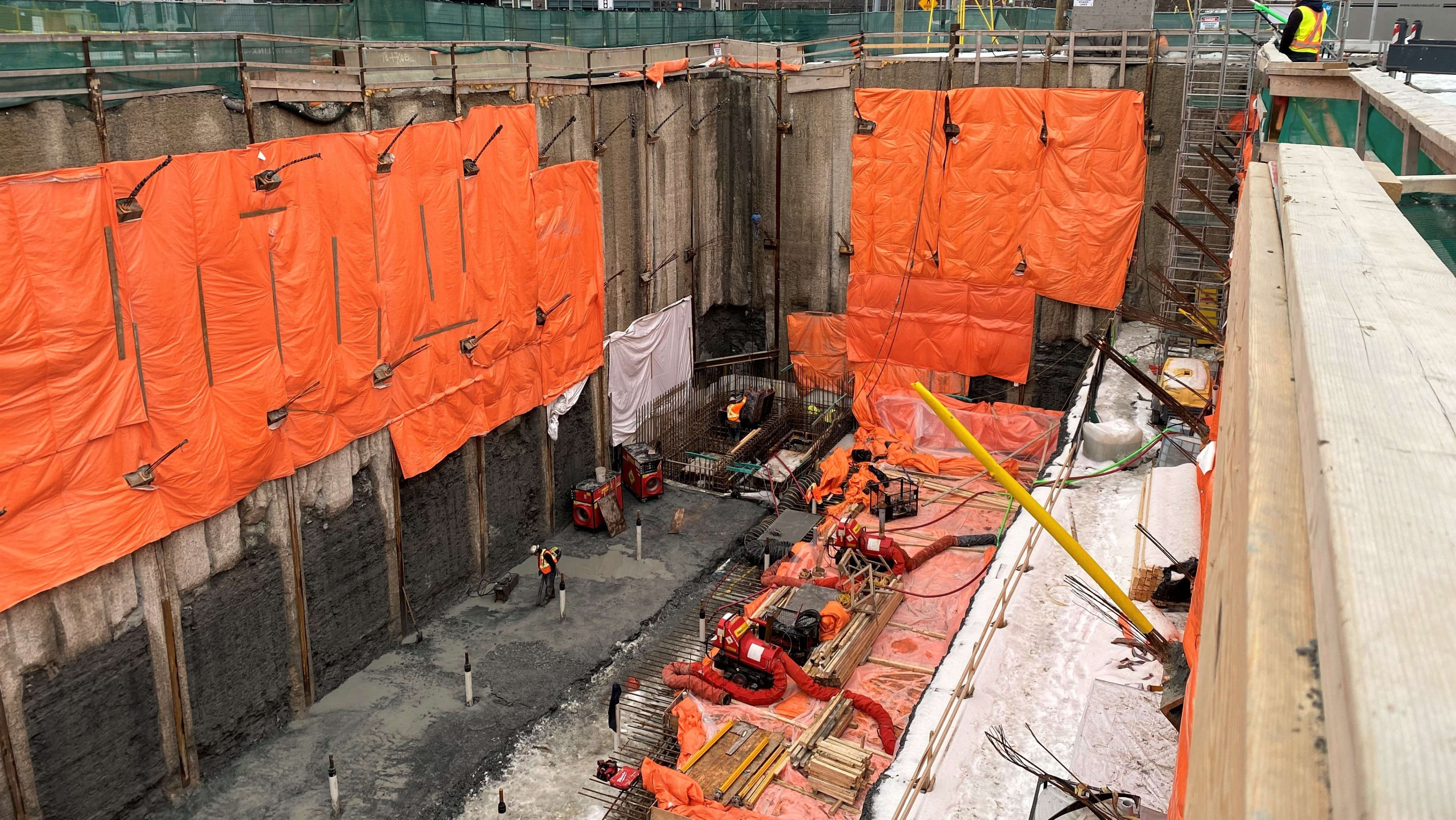 crews working deep in a pit with concrete pouring