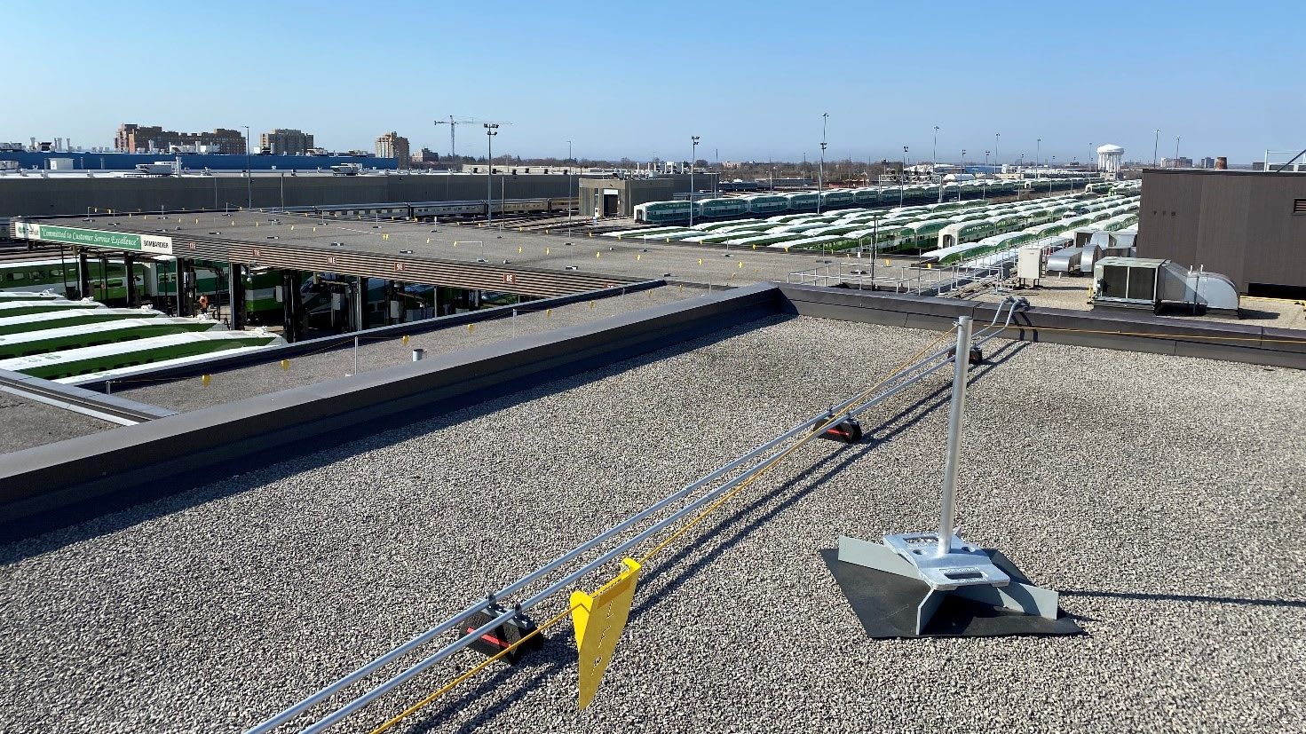 view from the roof of the train facility with the new warning lines installed and trains in the d...