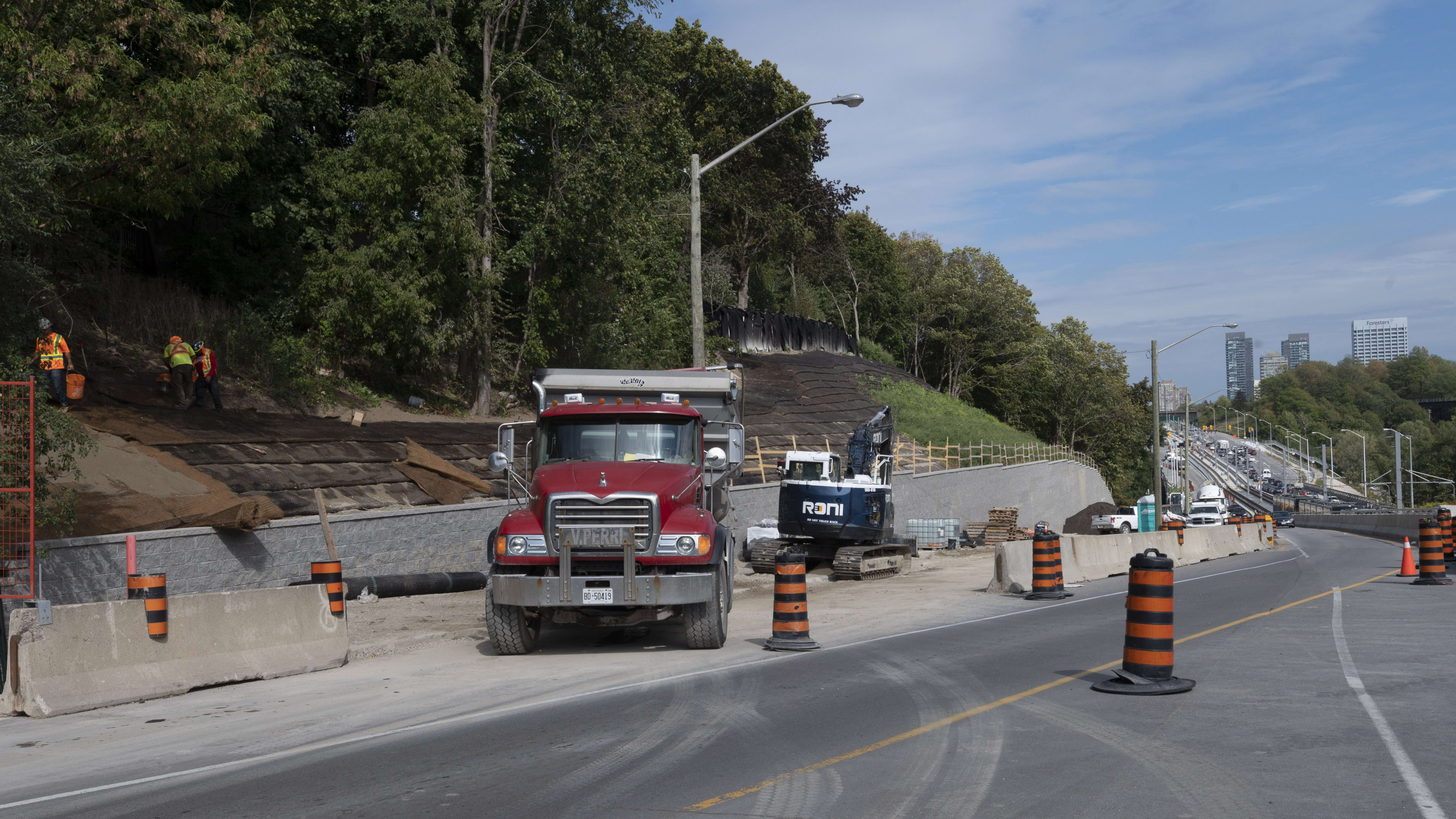 a dump truck next to a retaining wall.