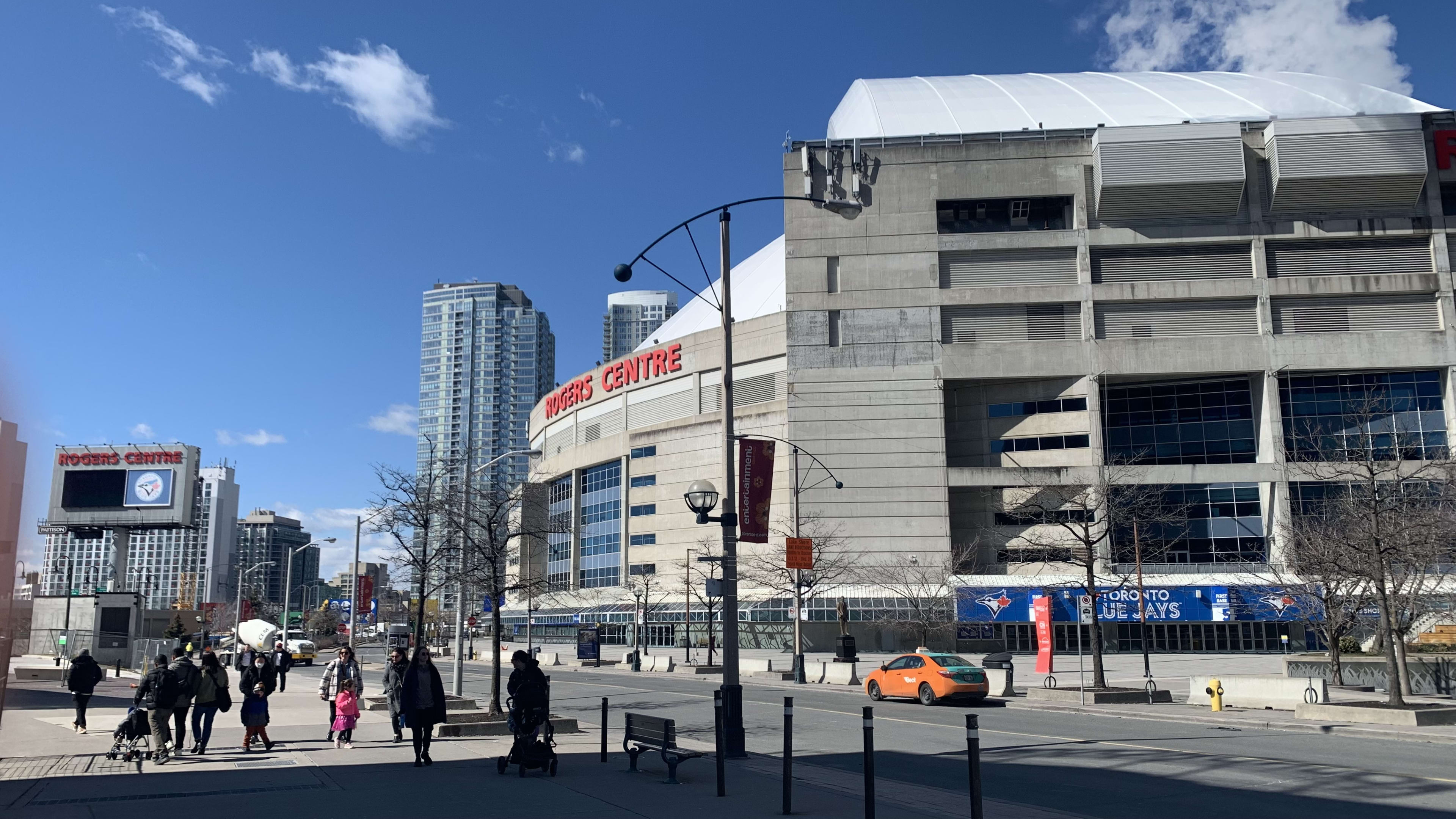 the Rogers Centre as people walk by it.