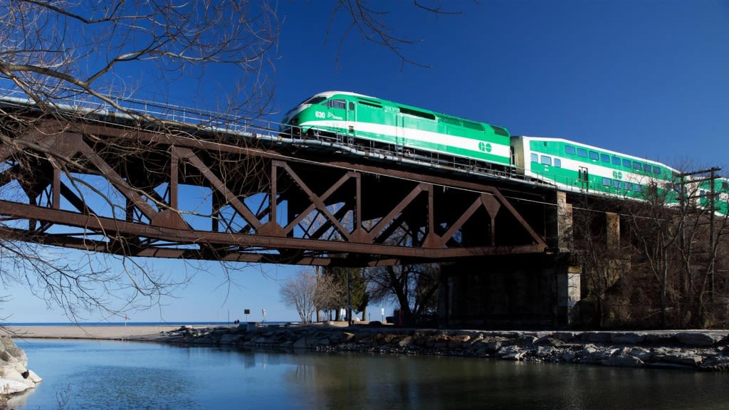 A GO Train passes over a rail bridge
