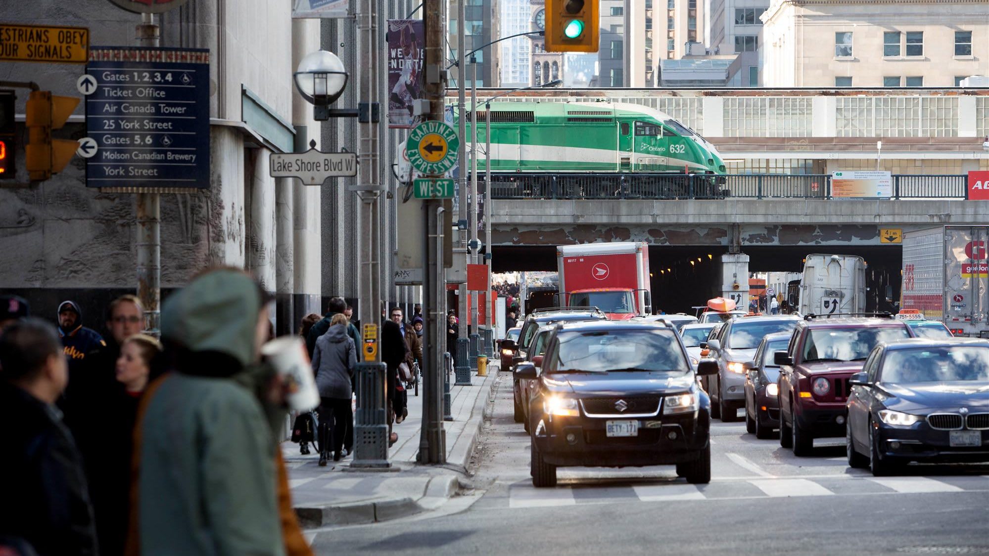 GO Train passes over bridge along Bay street