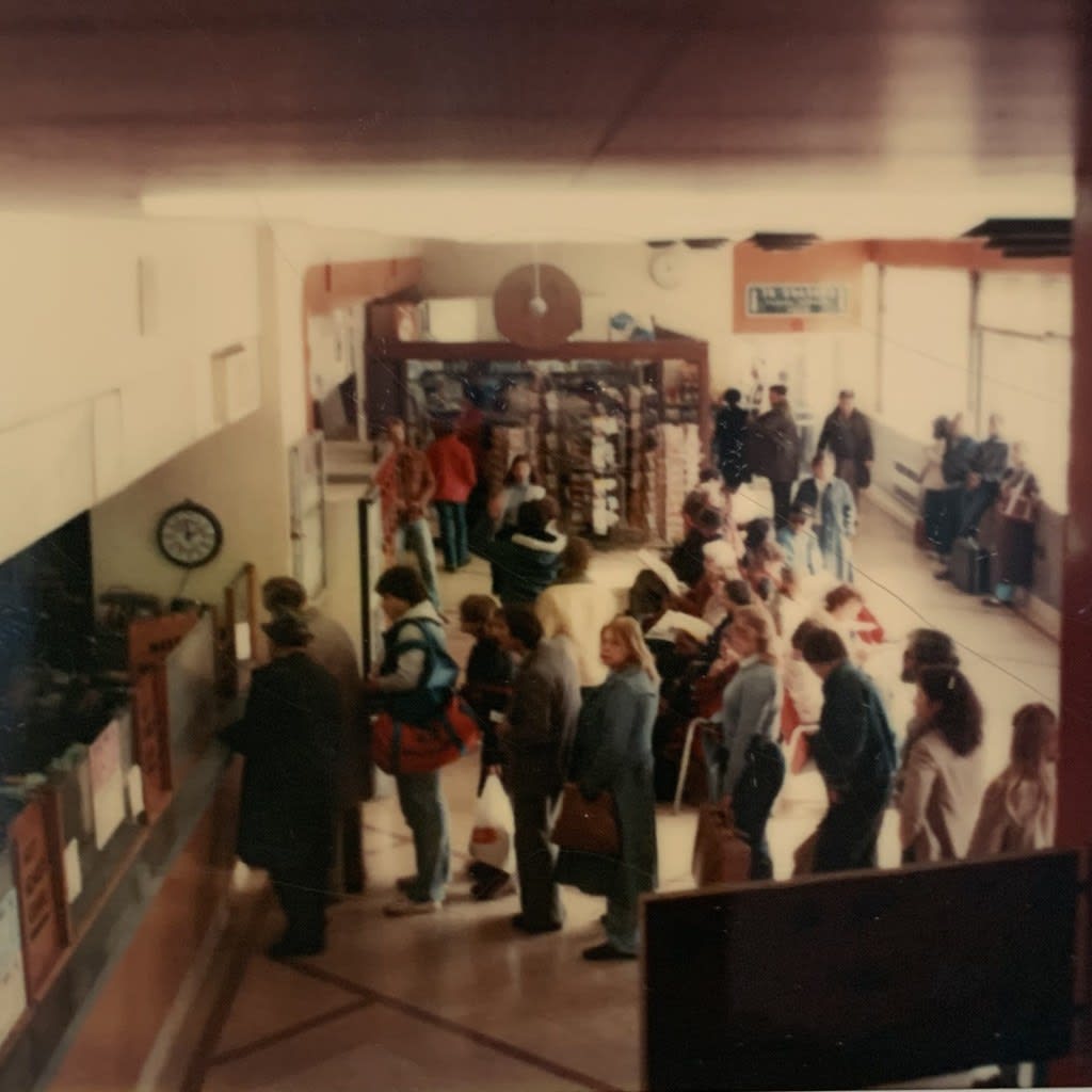 People are lined up at a ticket counter.