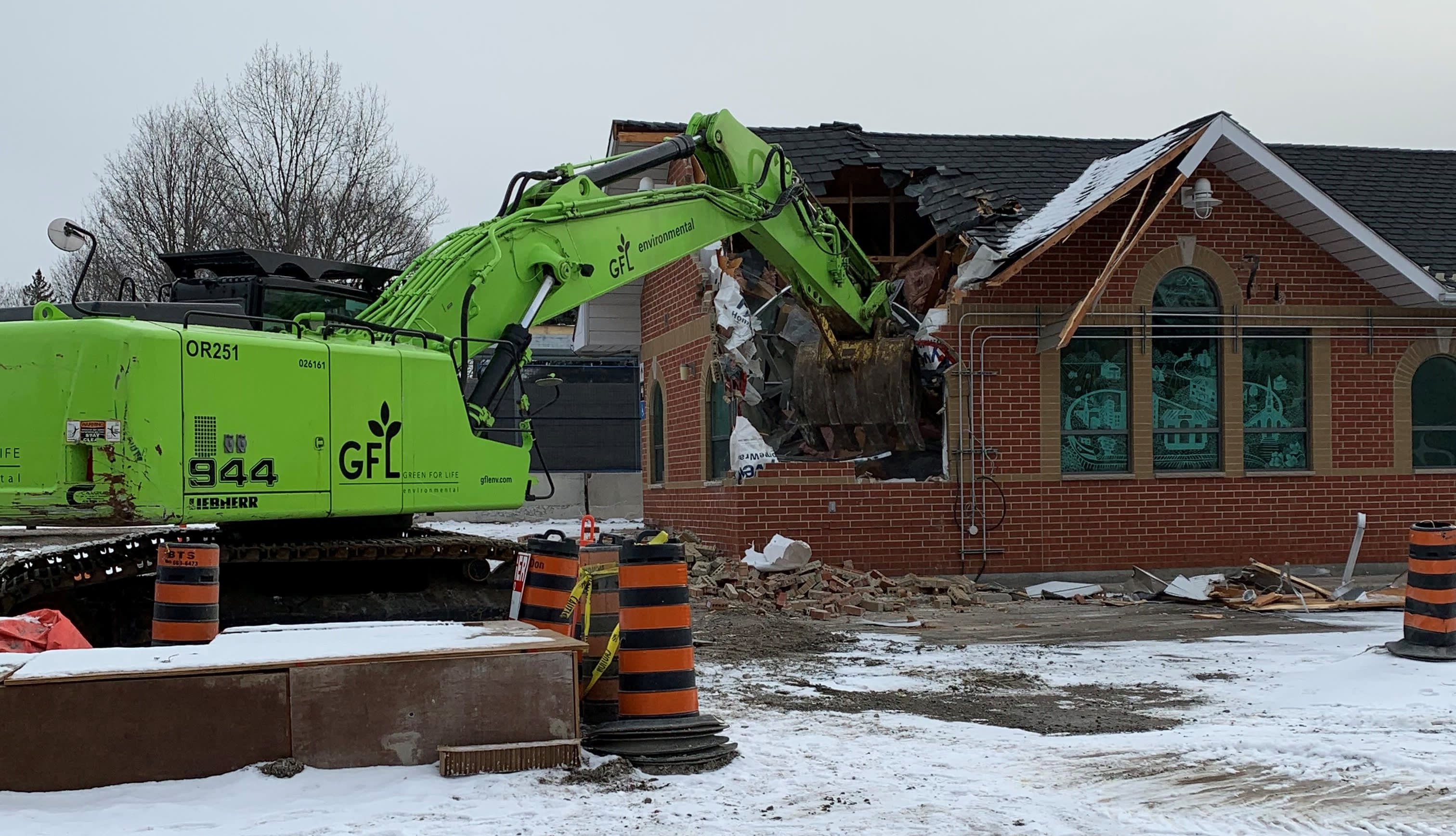 a tractor digging into the building.