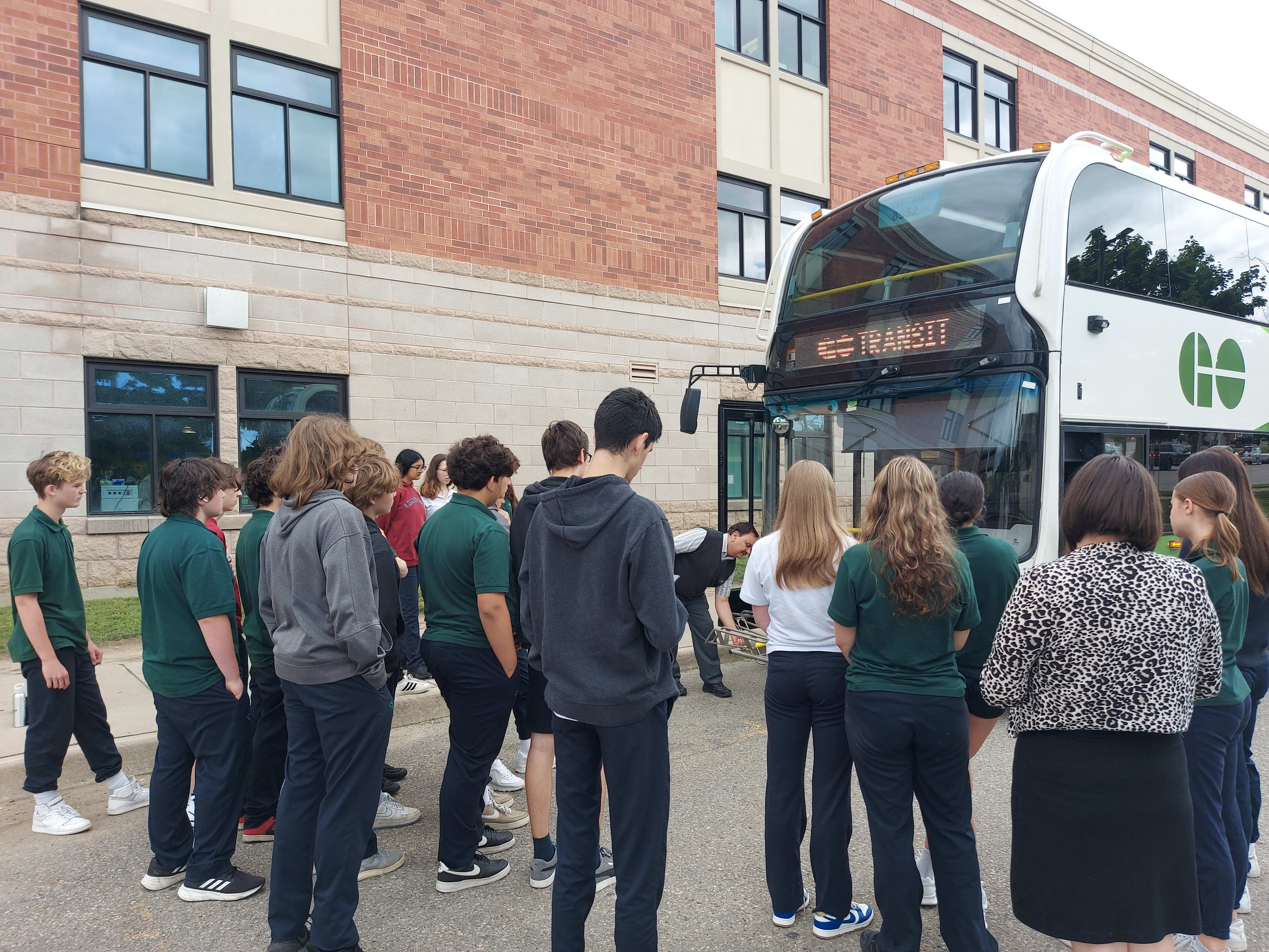 Students get a demonstration of the bike rack on a GO Bus