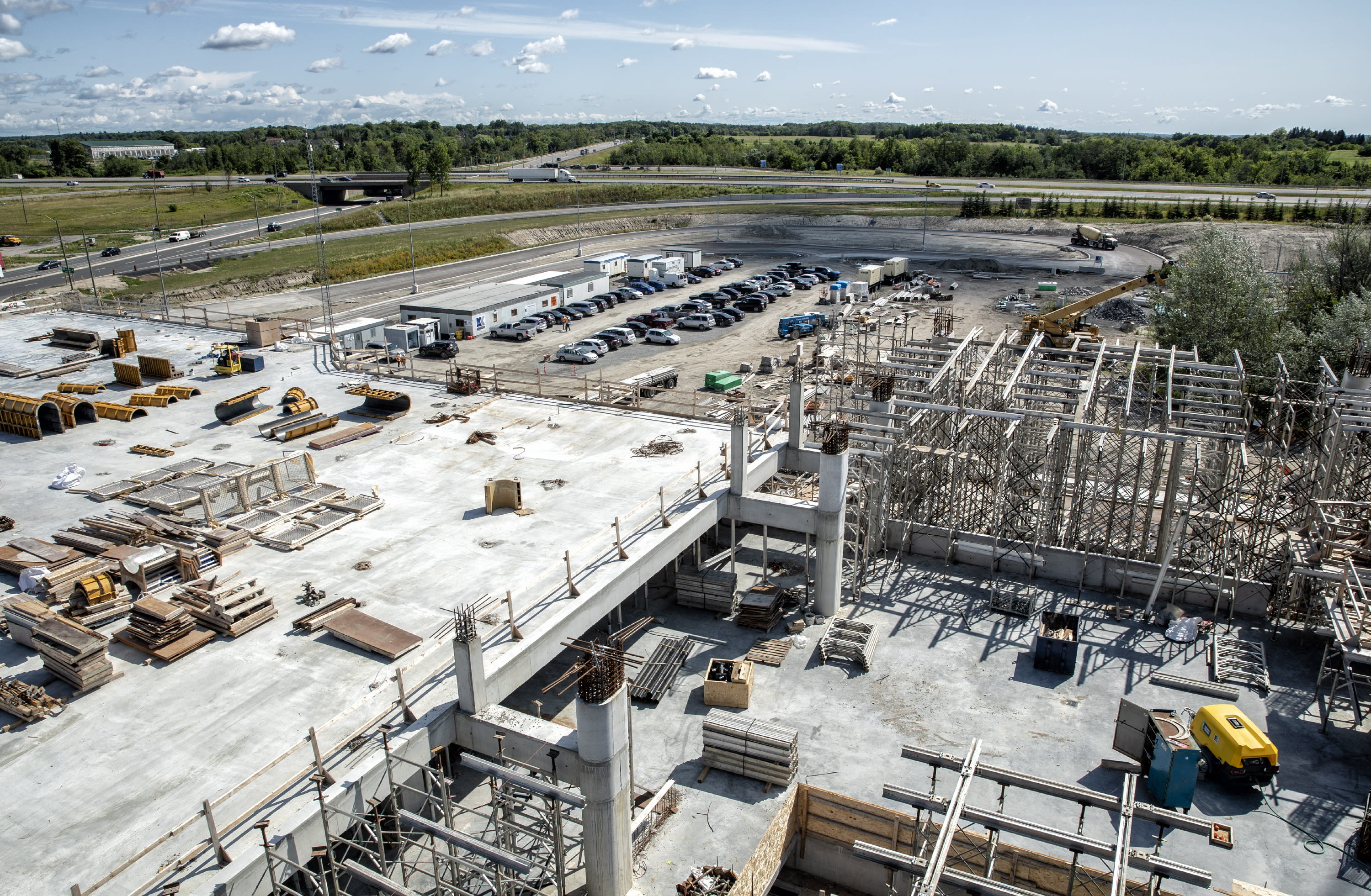 The building site, and nearby parking lot, are seen from a work crane.