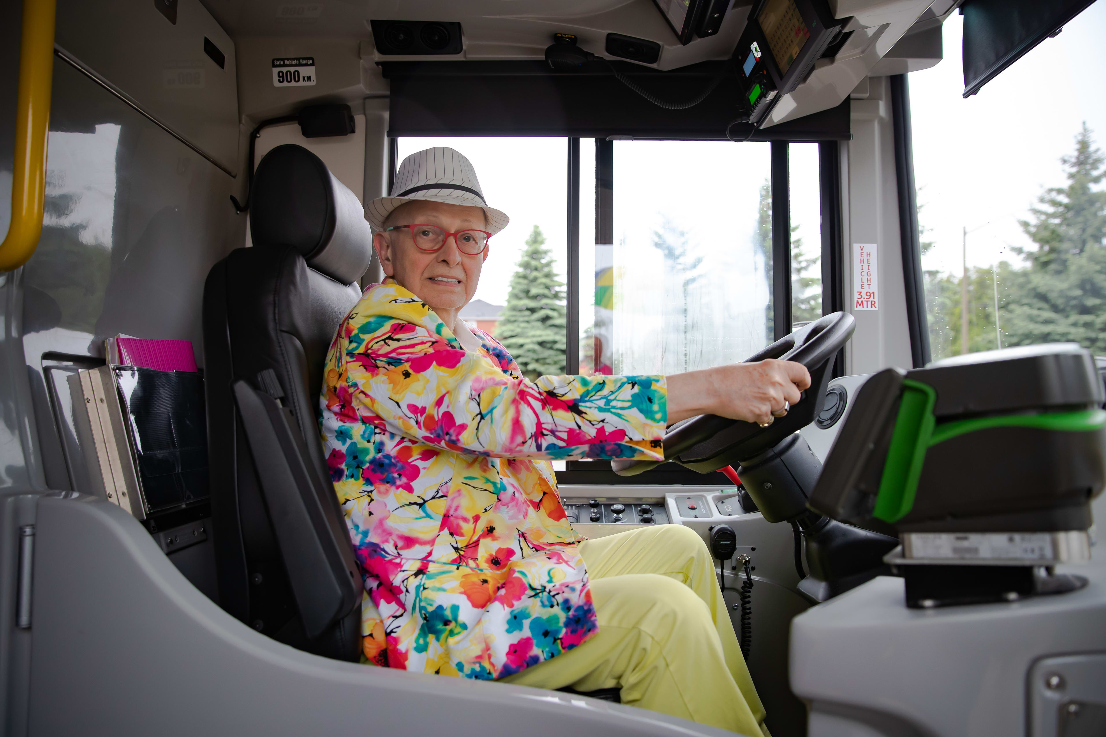 Russell poses as he has his hands on the wheel of a GO bus.