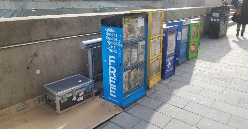 a large box beside newspaper boxes.