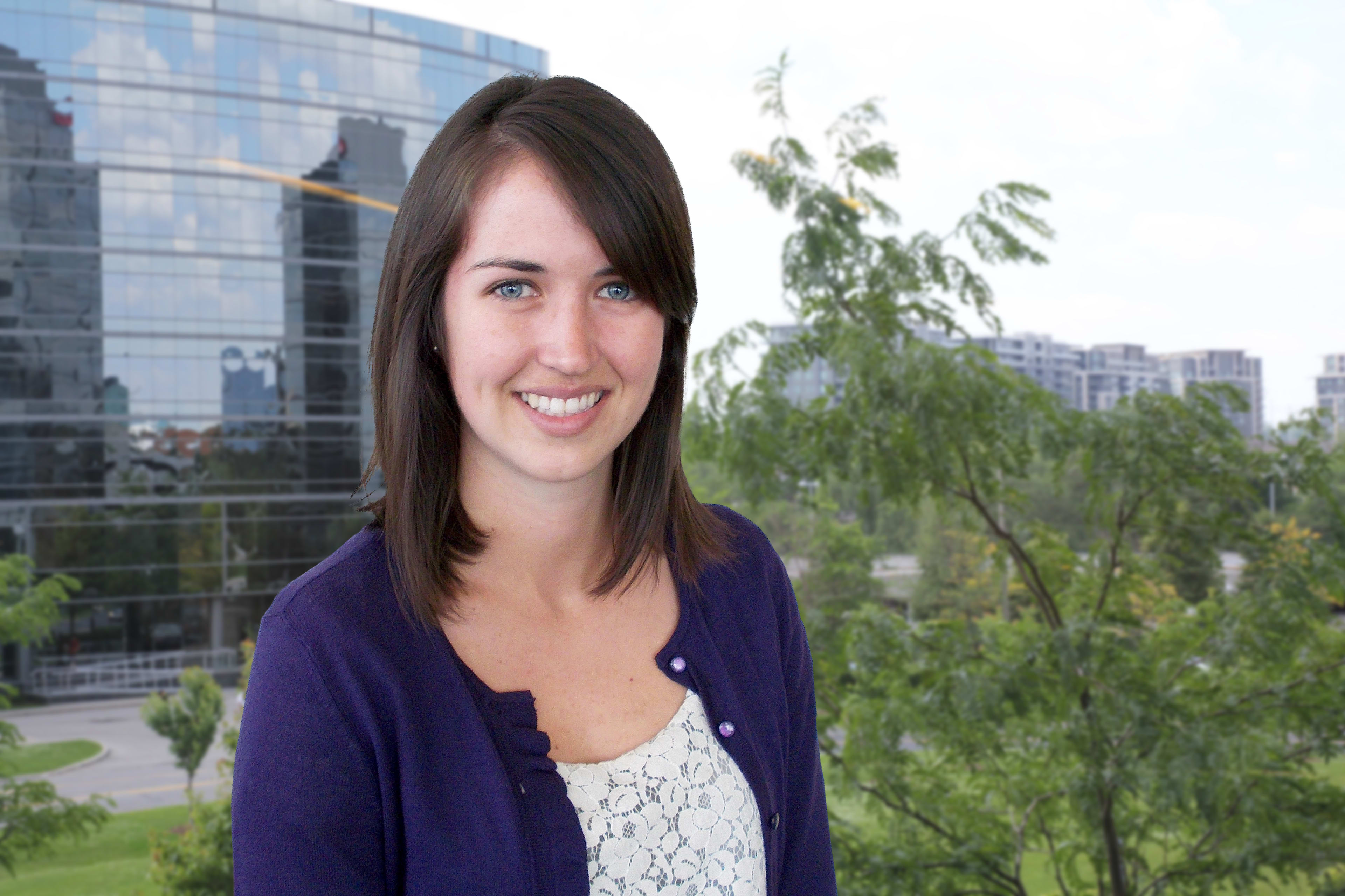 Meghan Bratt poses for the camera. Behind her a window looks out onto a green space.