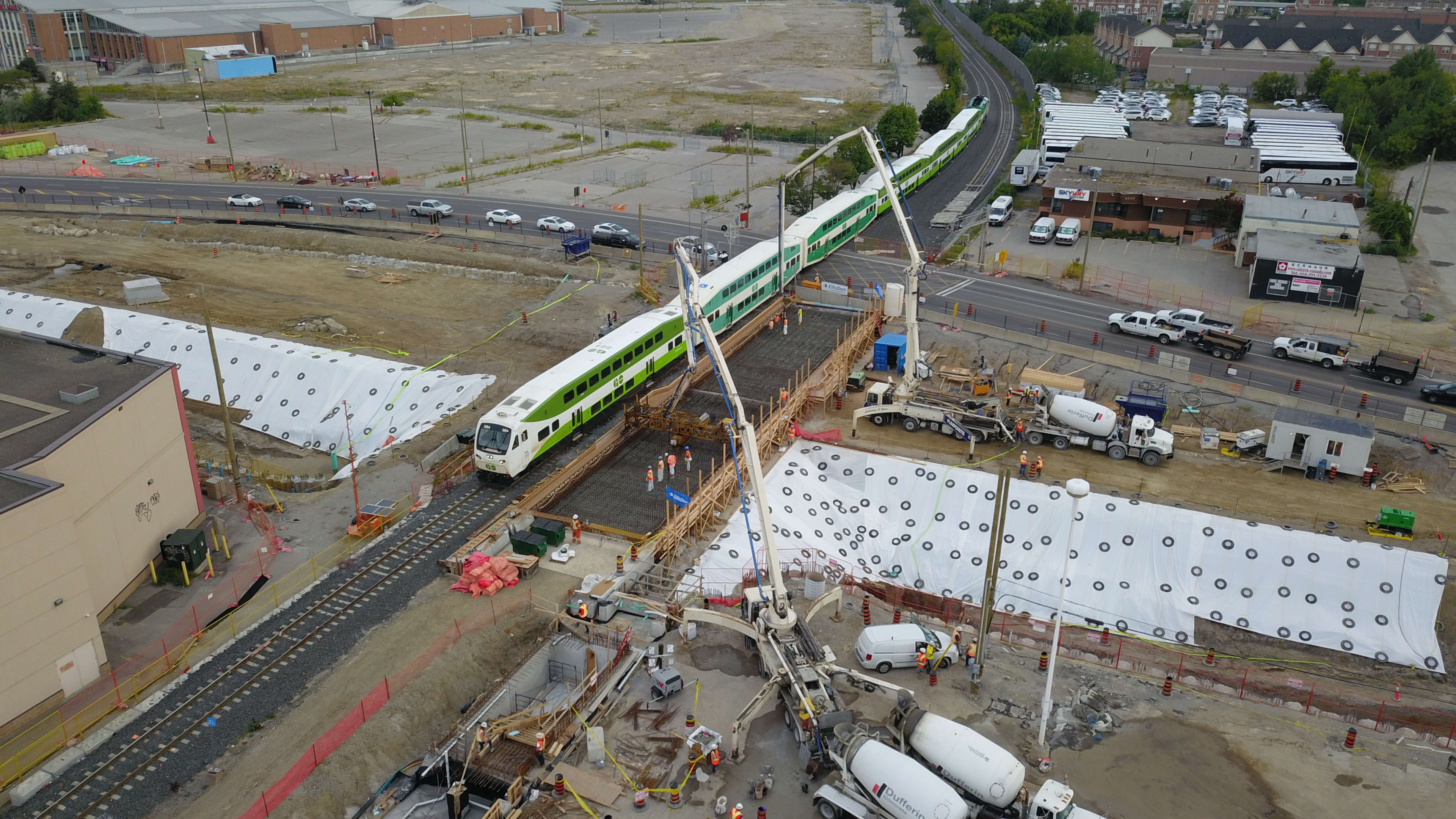 A GO train pass through the Steeles Avenue level crossing while construction goes on