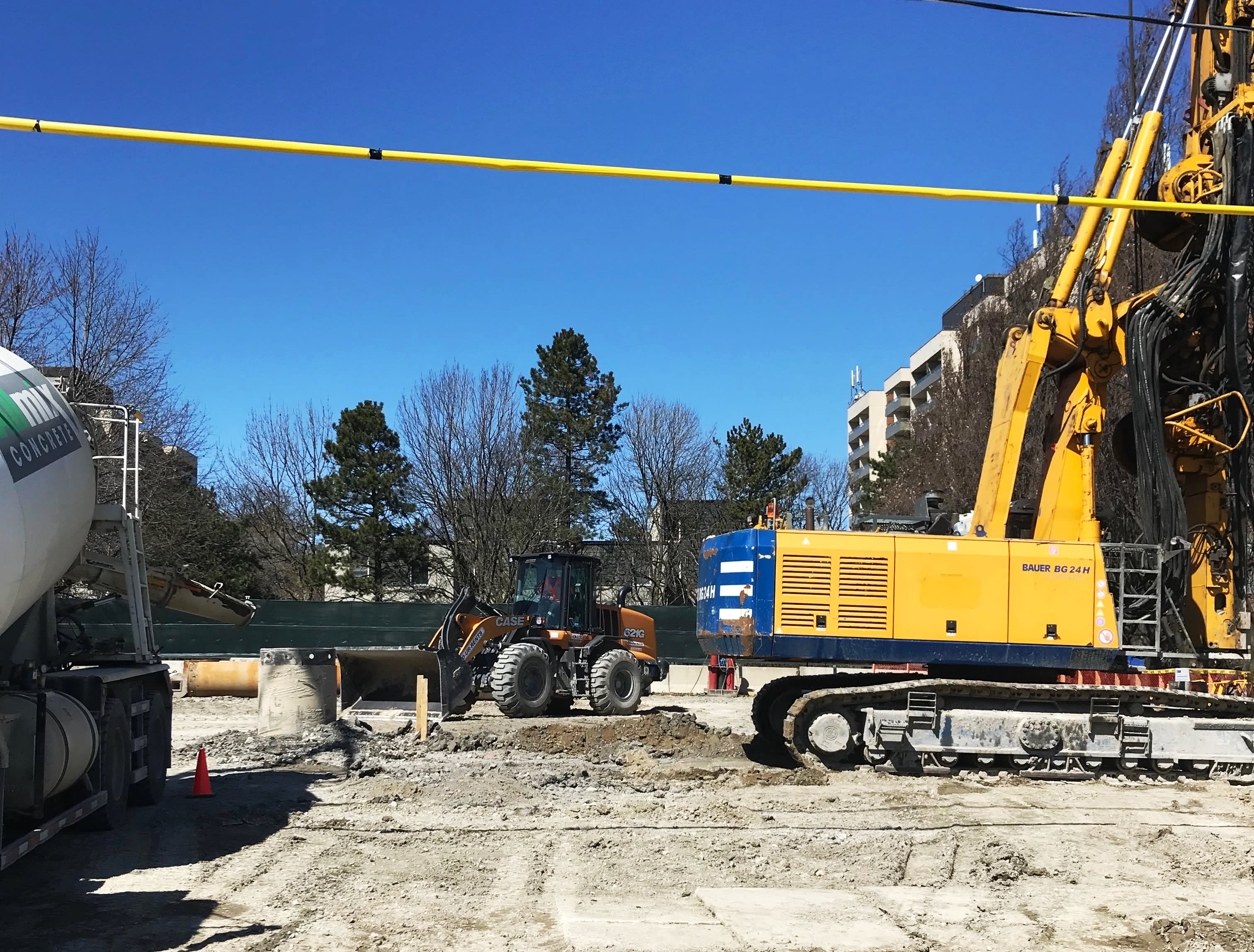 Construction machinery like excavators work on a Finch West LRT work site