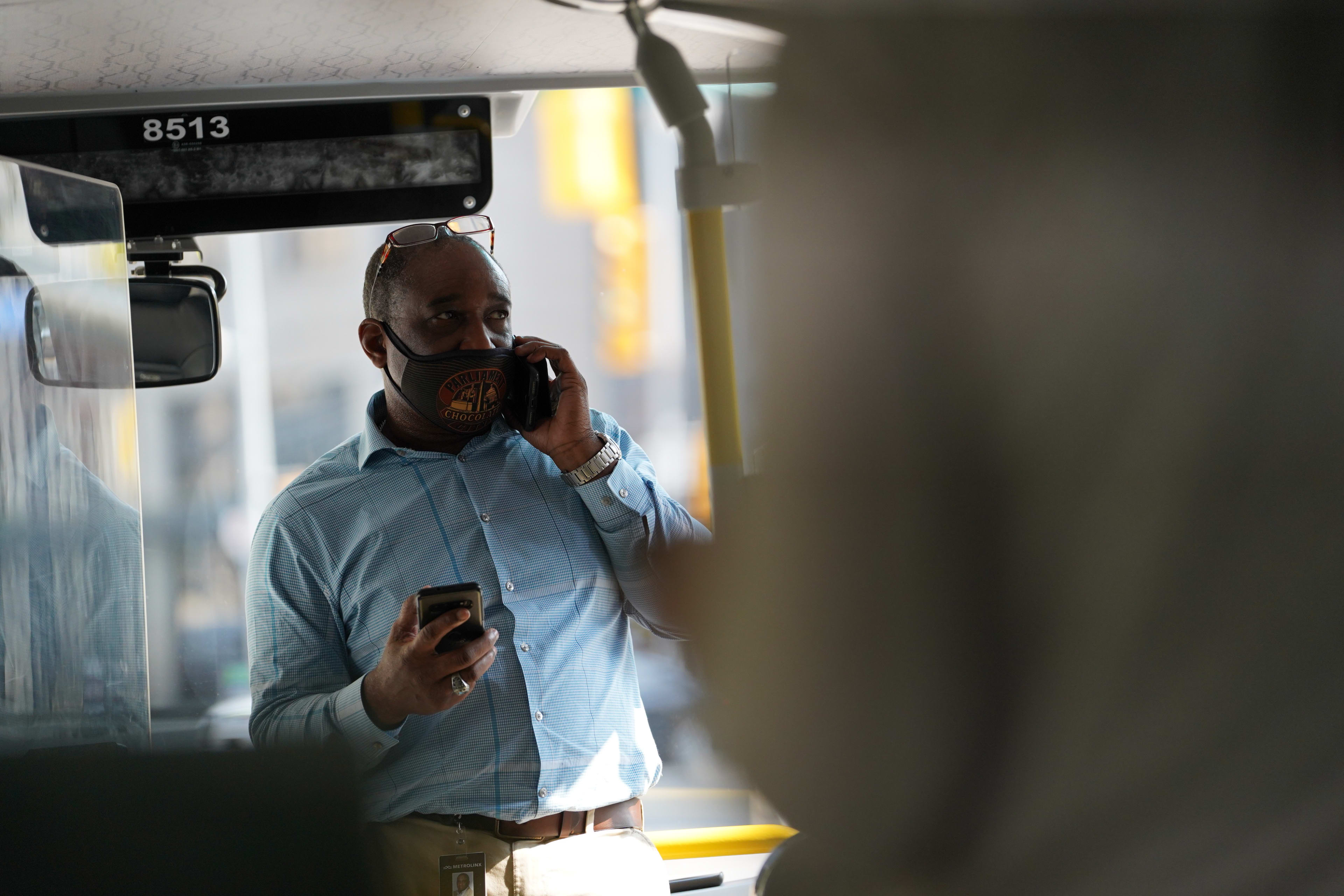 A man uses a phone on a GO bus.