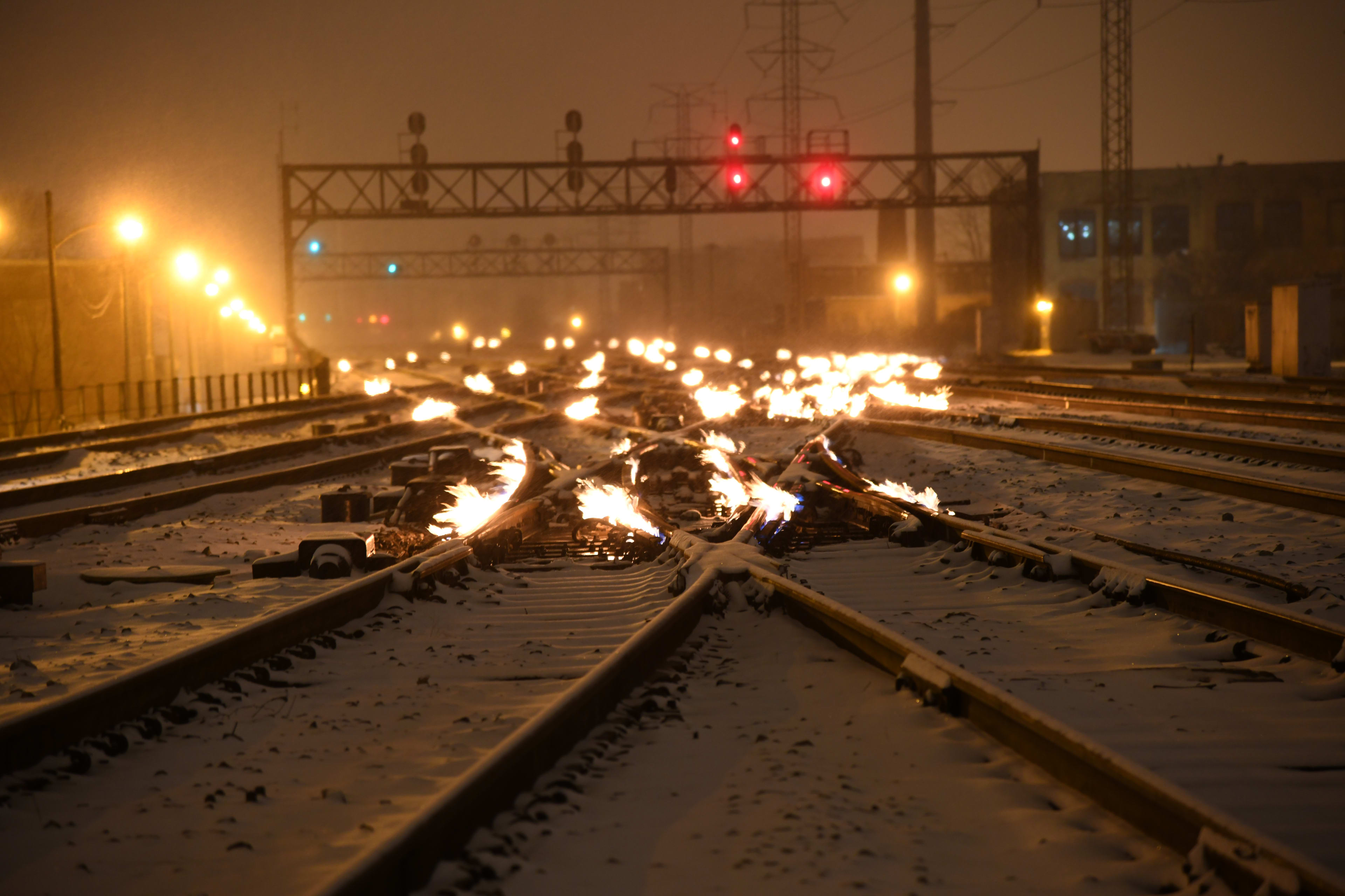 view of the tracks at night in winter, with gas fired flames on to keep switches clear in Chicago