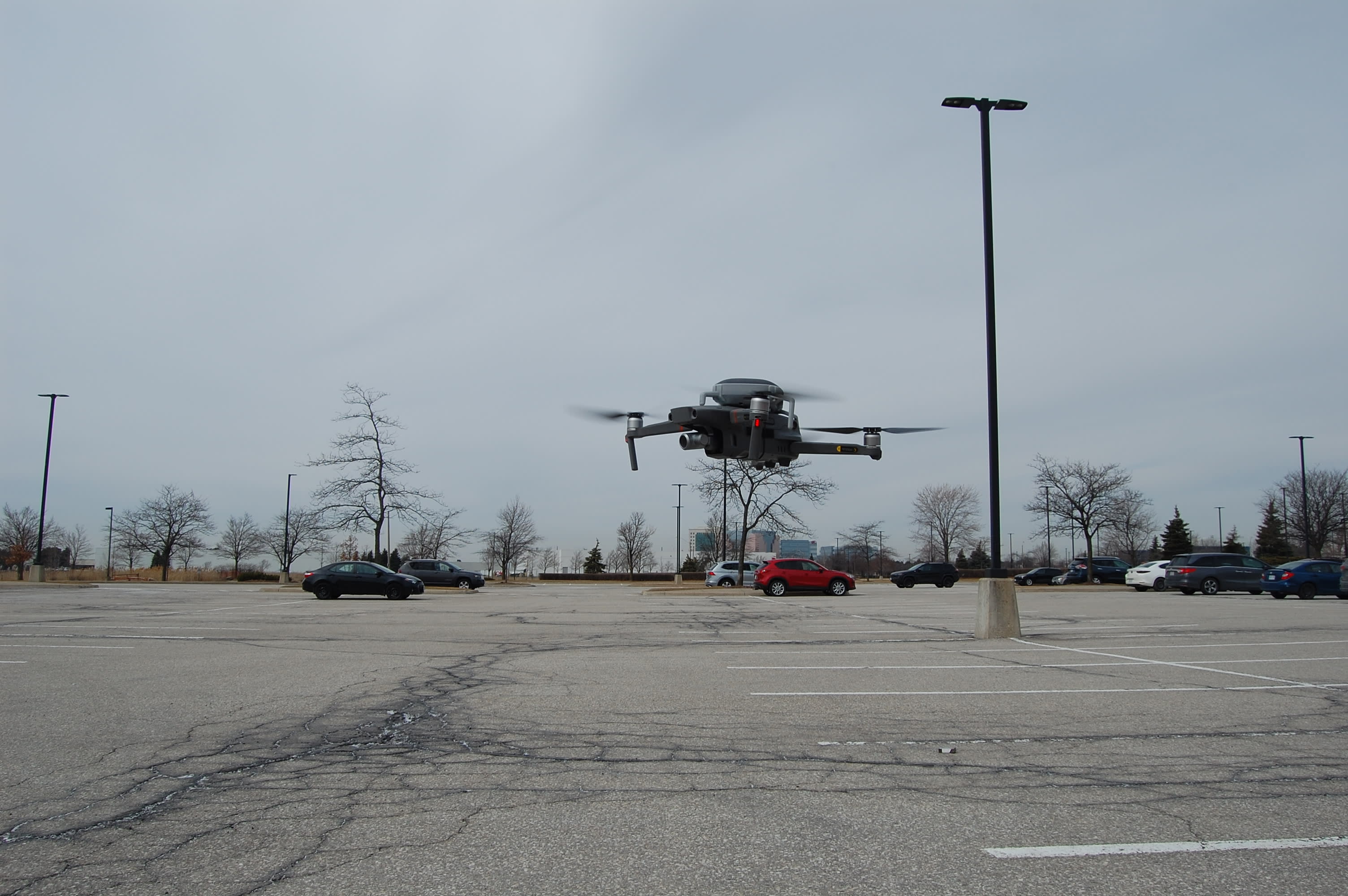 A drone takes off from a parking lot.