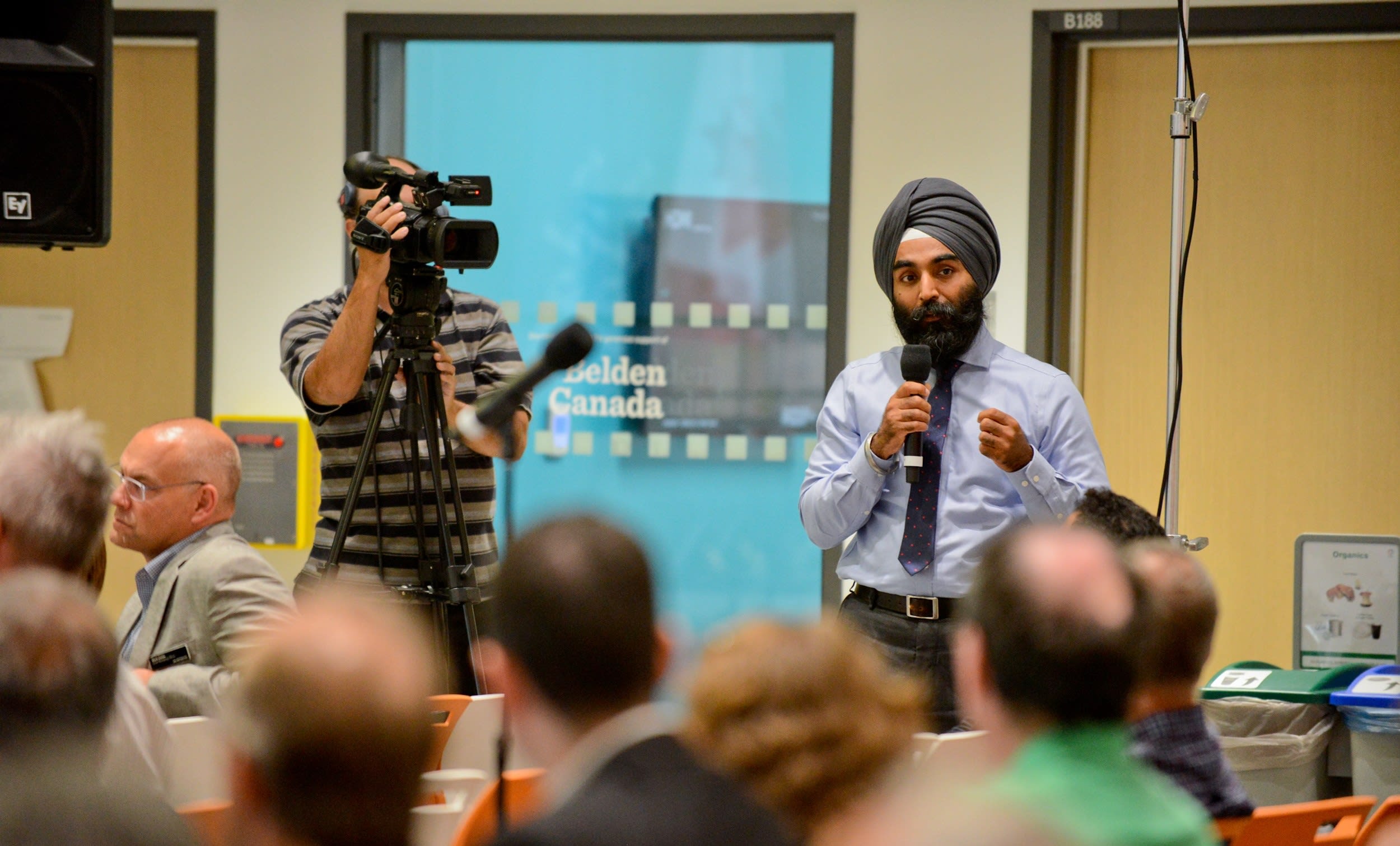Darshpreet Bhatti stands up to answer a question before the crowd.