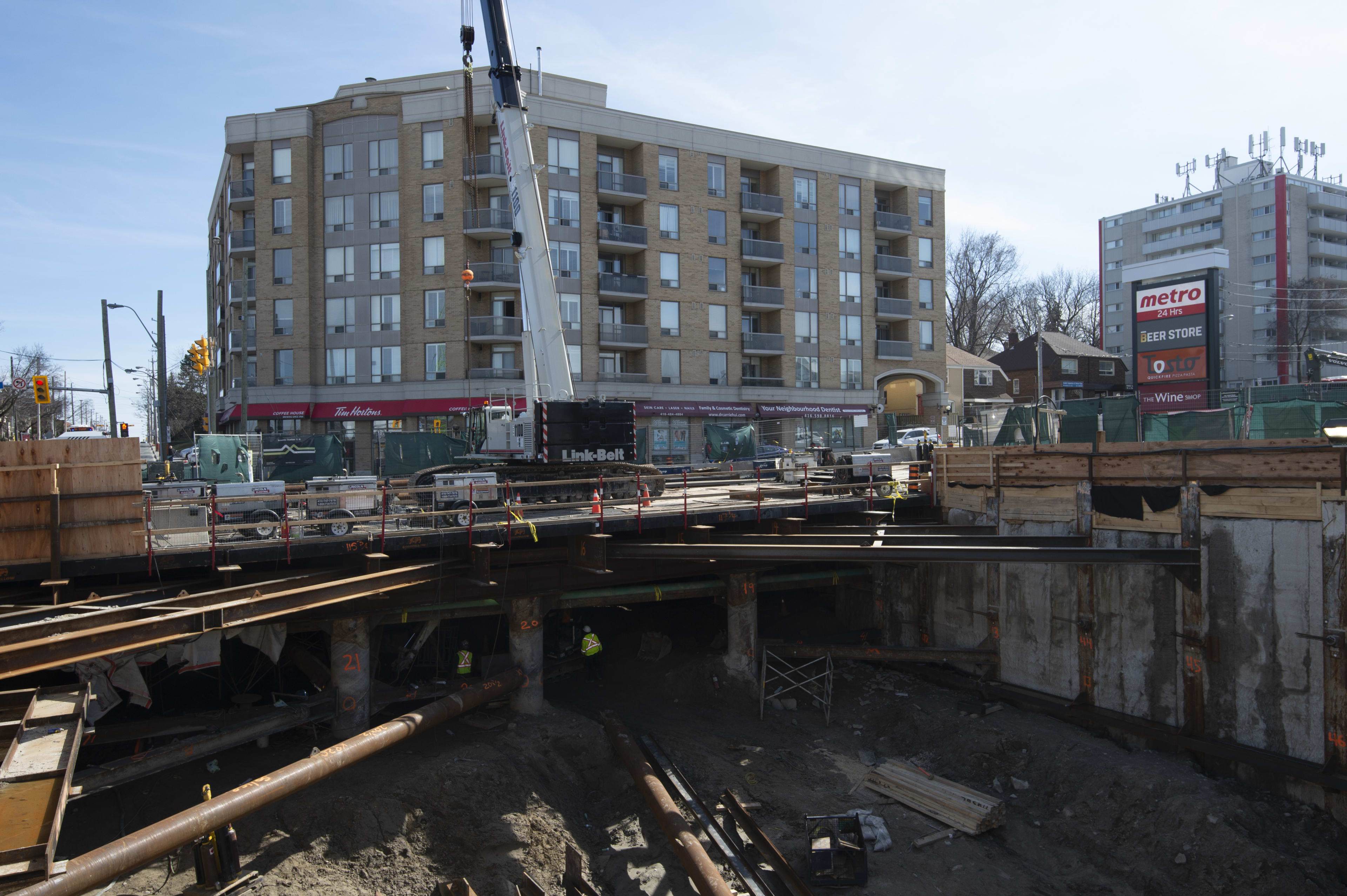 The photos shows a crane working above a construction pit.