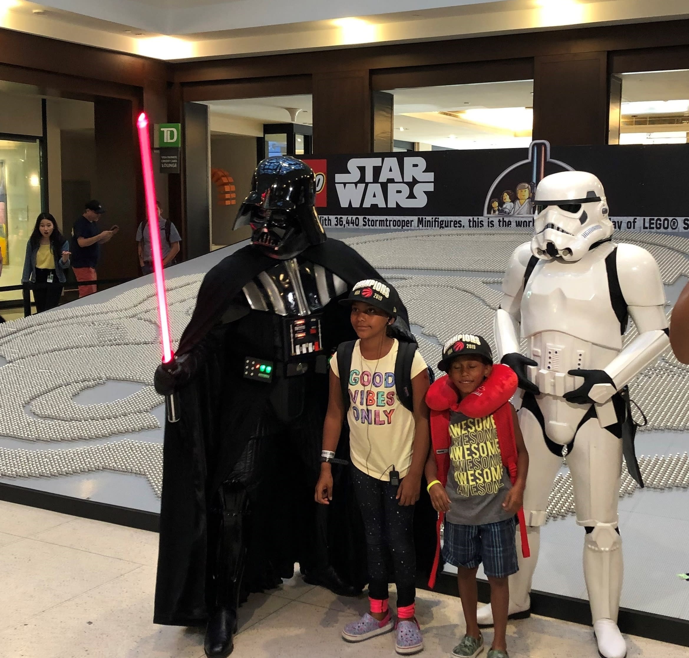Children stand next to Star Wars characters.