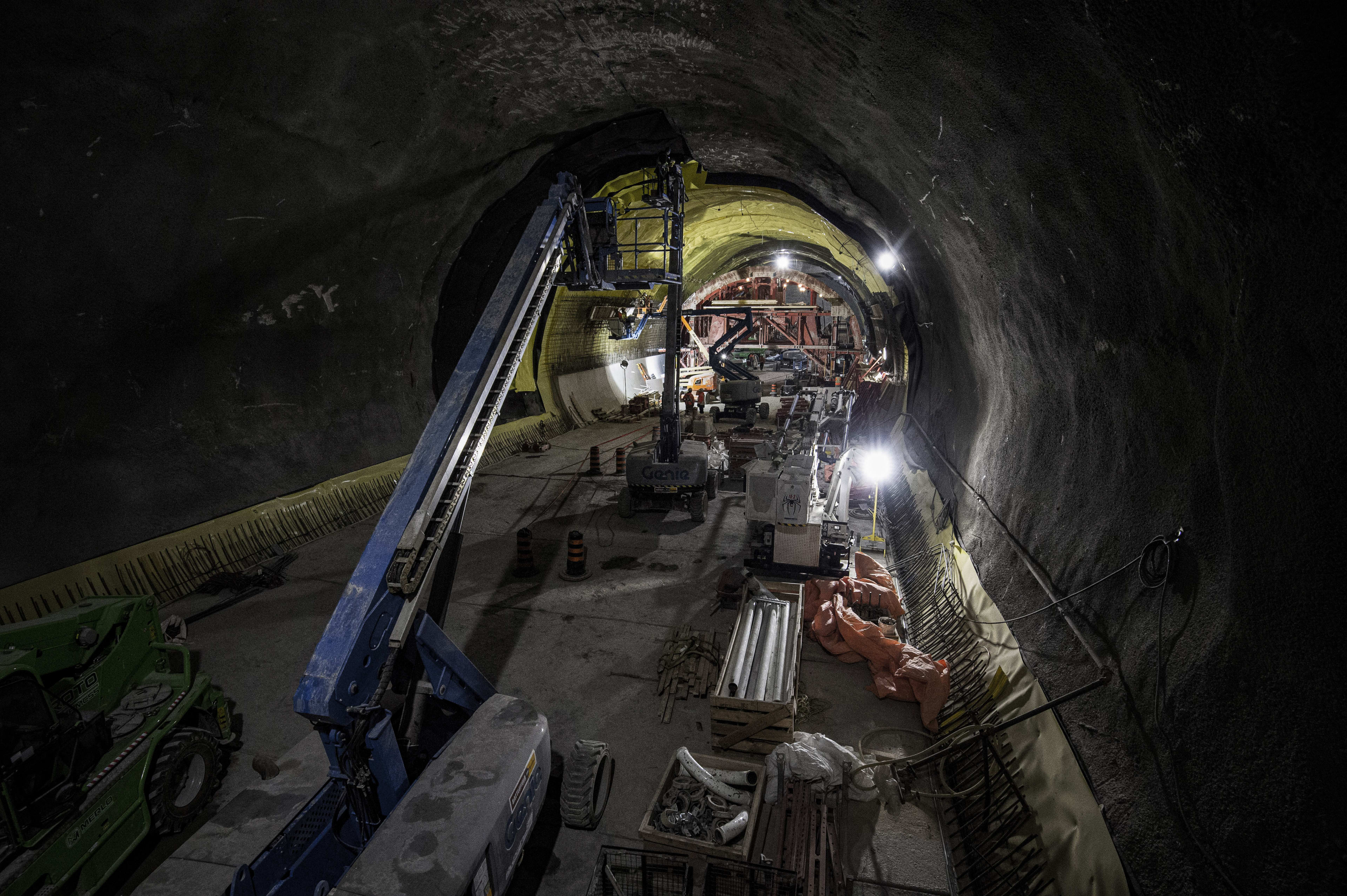 a large cavern with crews putting up plastic waterproofing sheets.