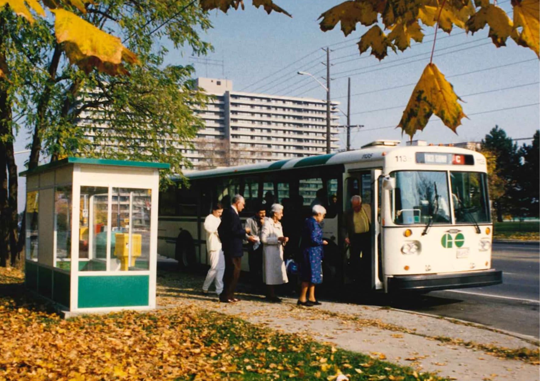 People get on a bus in the 1970s.