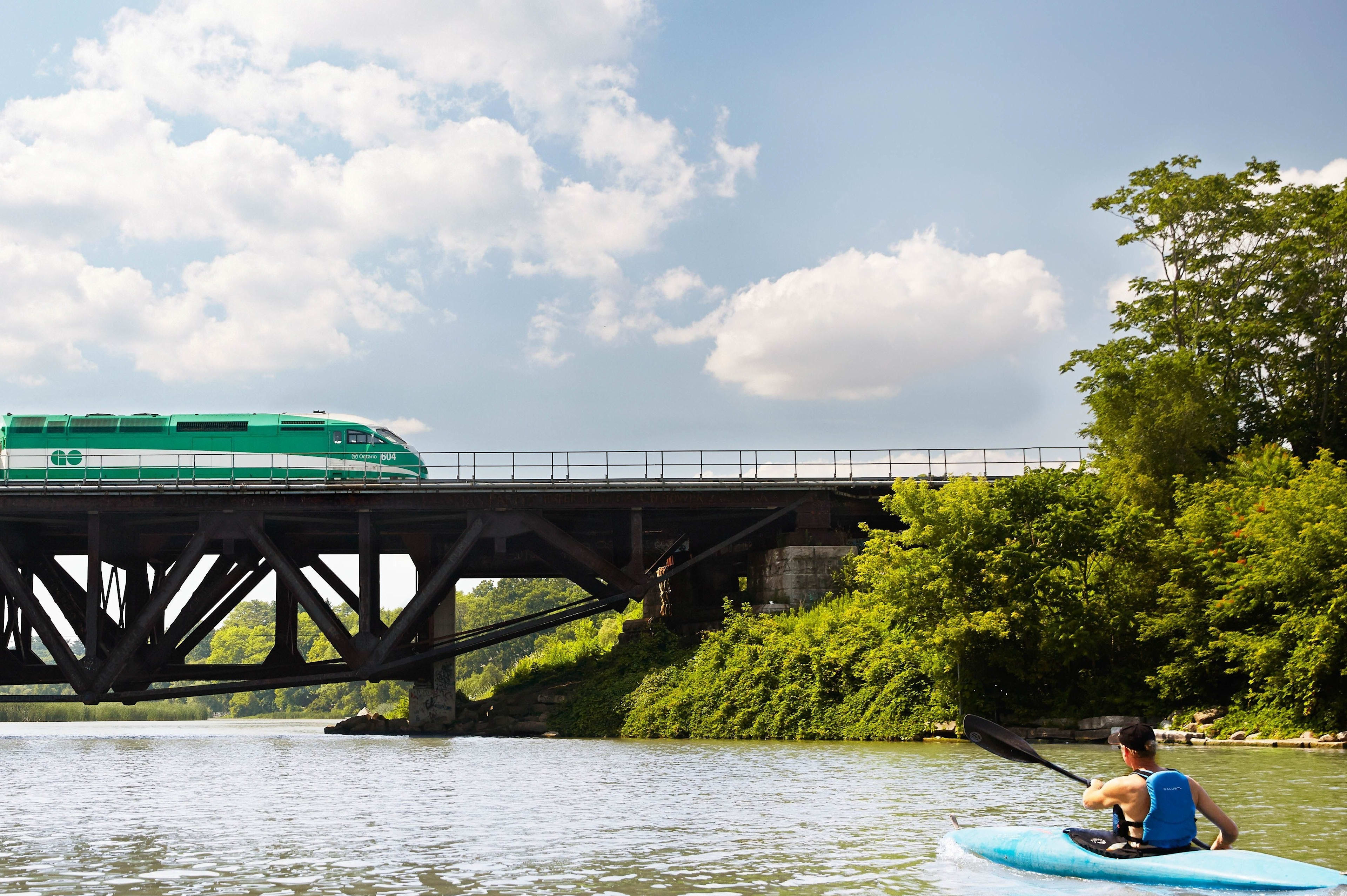 kayaker approaching GO Train bridge