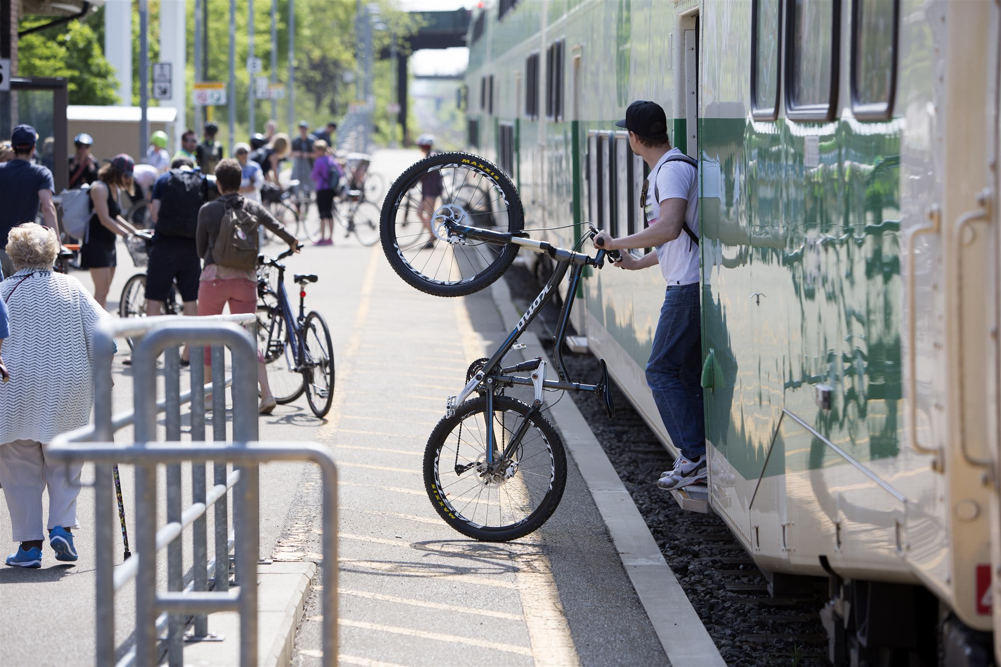 Man exiting GO Train with bicycle
