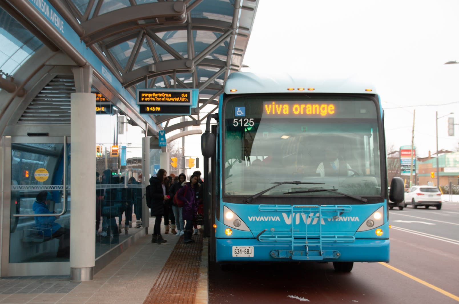 A VIVAnext york region transit bus sits parked as customers climb on board