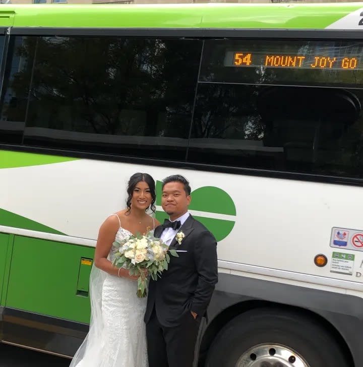 Couple takes wedding photos in front of GO bus where they met